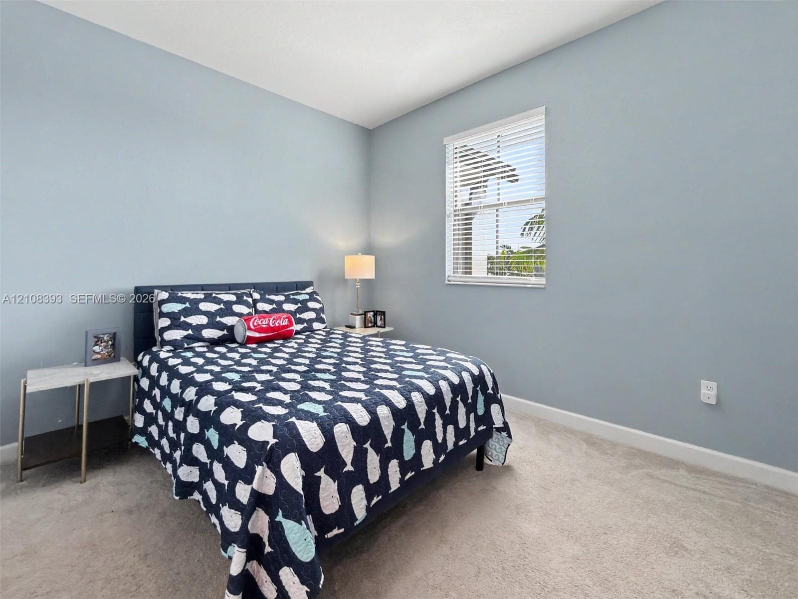 Neutral-toned carpeted flooring, light-colored wall finish, and a rectangular window with horizontal blinds
