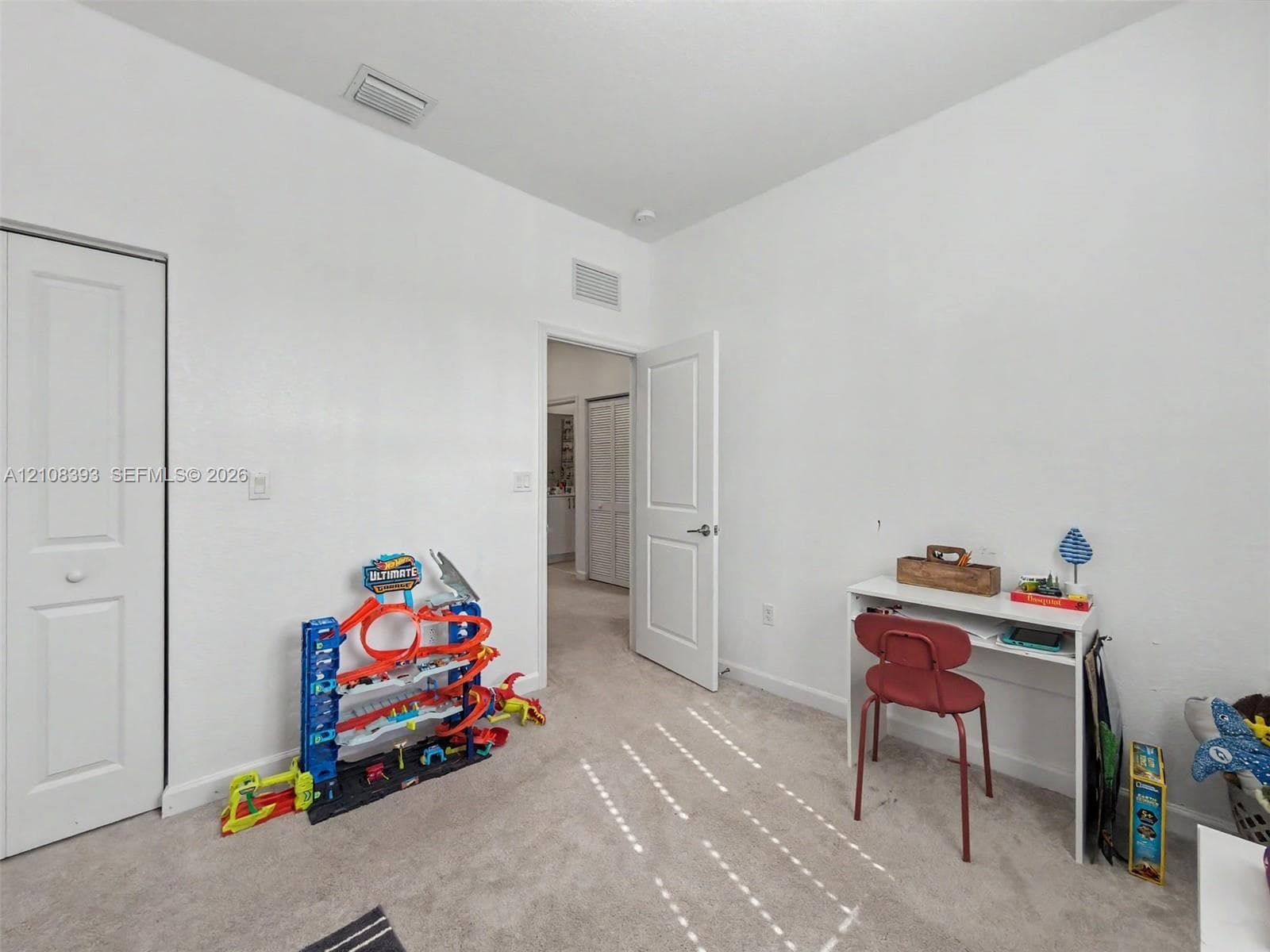 Interior space featuring neutral-toned carpeting, two-panel interior doors, and a closet with a bi-fold door