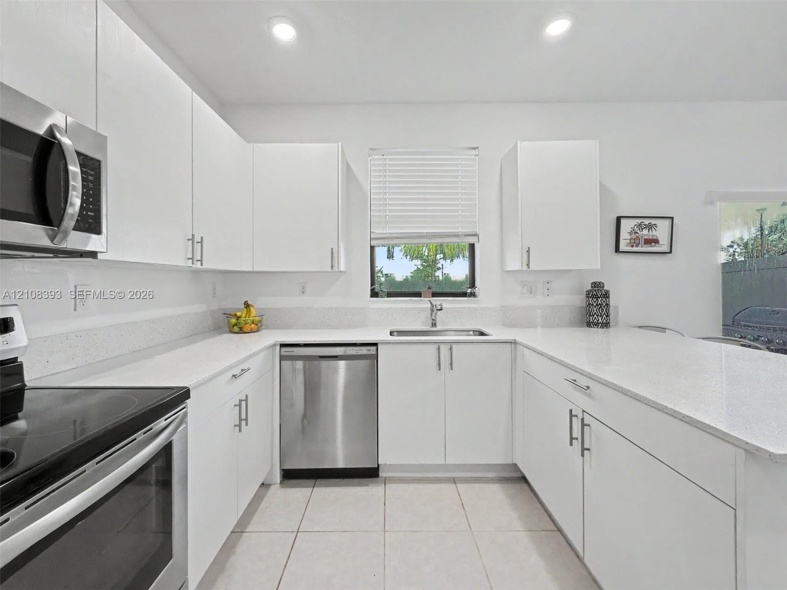 Kitchen featuring white cabinetry, solid-surface countertops, recessed lighting, and stainless steel appliances
