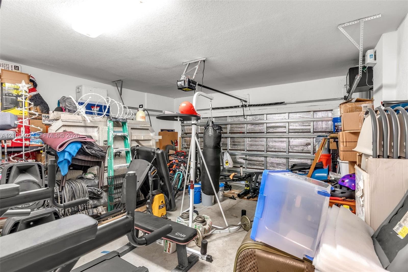 Garage space featuring a metal sectional overhead door and an installed motorized door opener
