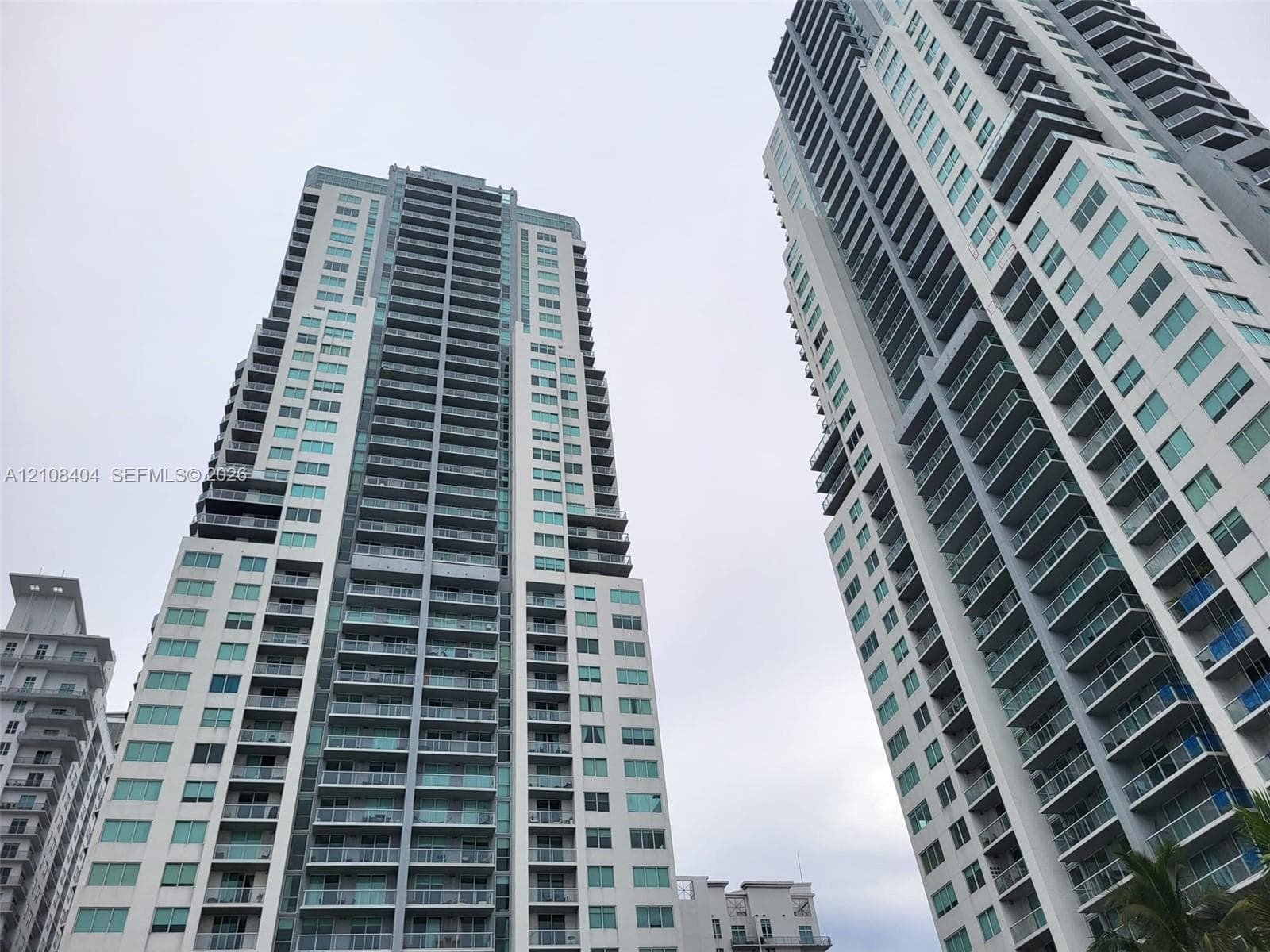 High-rise architectural exterior featuring glass-railed private balconies, floor-to-ceiling windows, and contemporary masonry facade