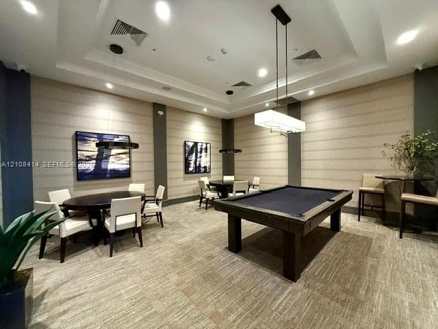 Recreation space featuring a coffered ceiling, recessed lighting, linear pendant light fixtures, and wall-to-wall patterned carpeting