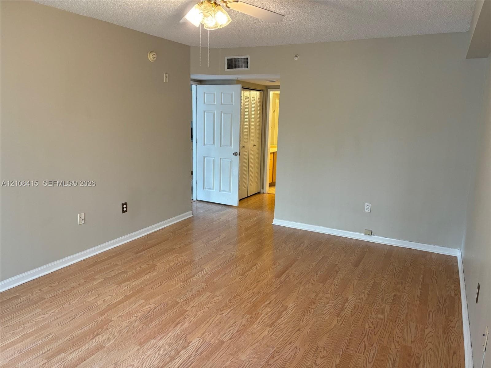 Living area featuring wood-finish flooring, neutral wall paint, and a ceiling-mounted light fixture