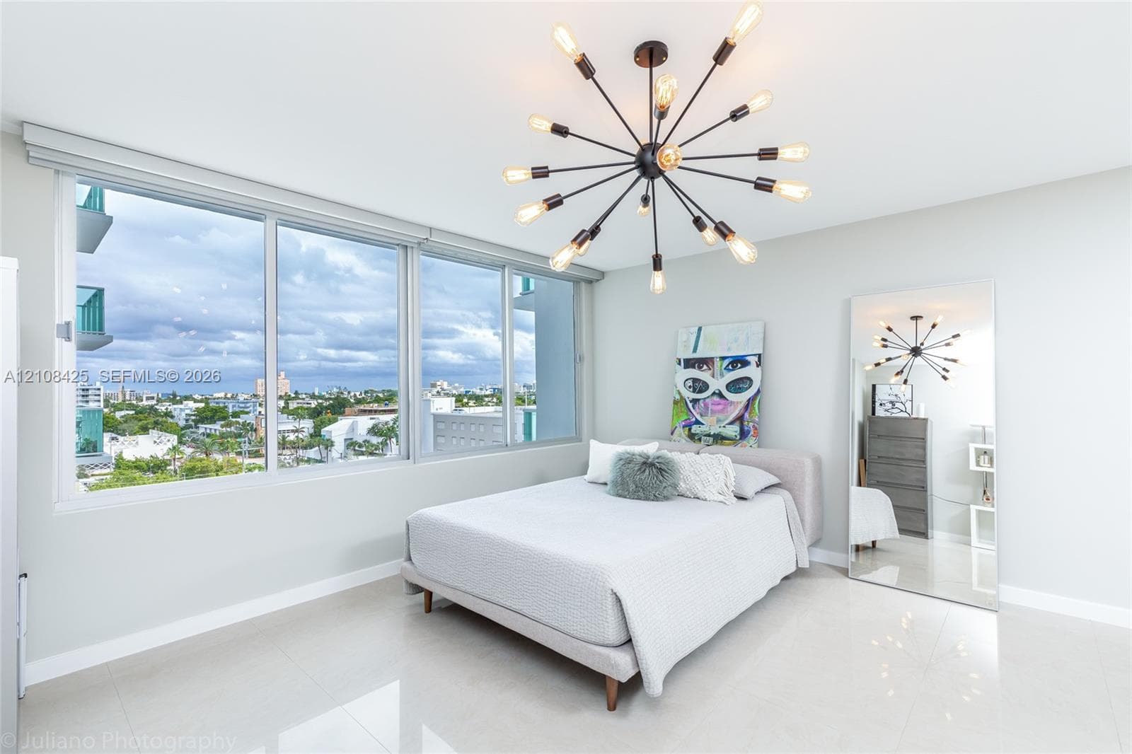 Floor-to-ceiling windows, polished tile flooring, and a multi-arm sputnik chandelier