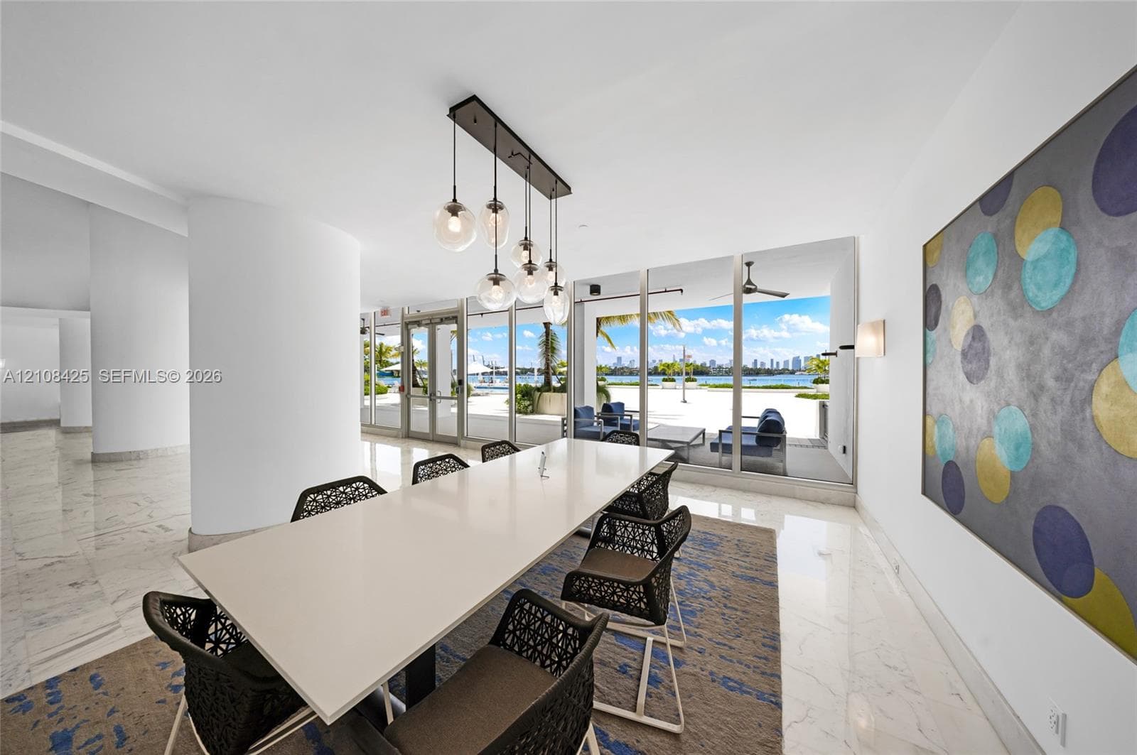 Floor-to-ceiling glass windows, polished stone flooring, multi-globe pendant chandelier, and recessed wall lighting