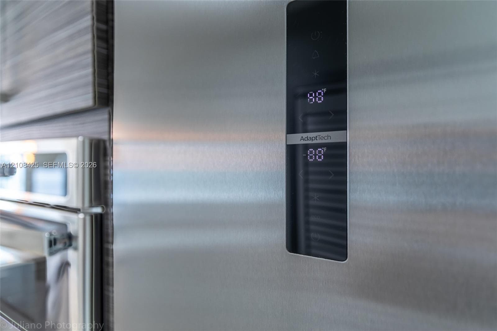 Stainless steel refrigerator featuring a digital touch-control interface and wood-grain textured cabinetry
