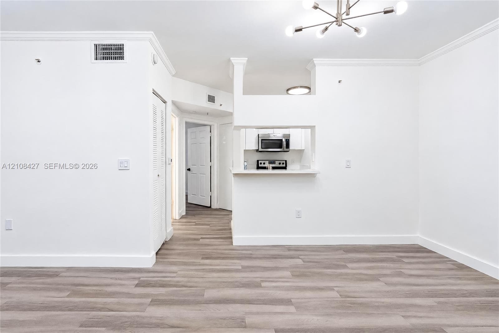 Grand hall featuring soaring ceilings, oversized structural columns, large-scale tile flooring, and custom built-in wood cabinetry with integrated shelving