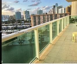 Private balcony featuring tile flooring and a glass-panel railing