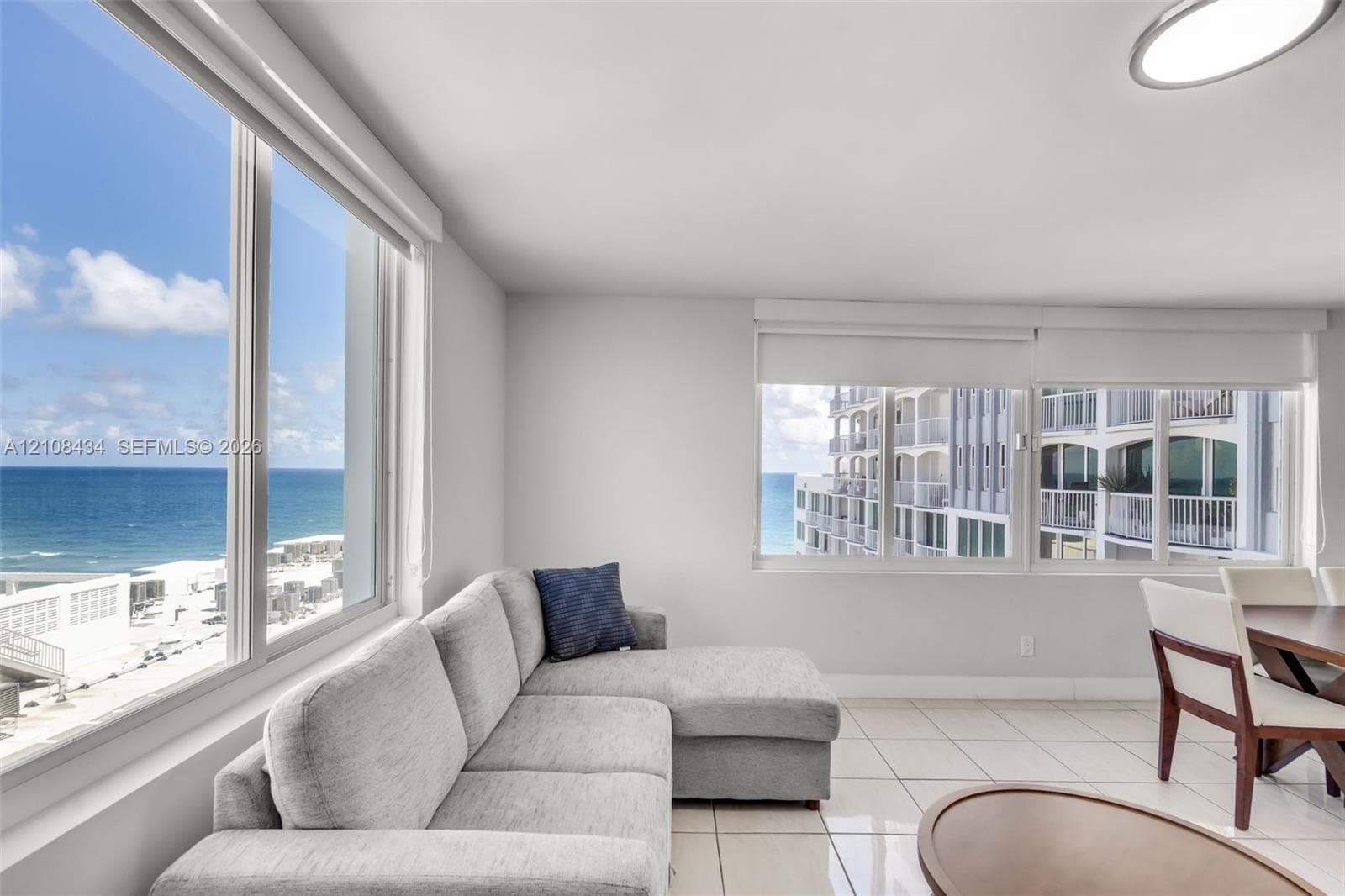 Floor-to-ceiling windows featuring ocean scenery, ceramic tile flooring, and integrated recessed lighting