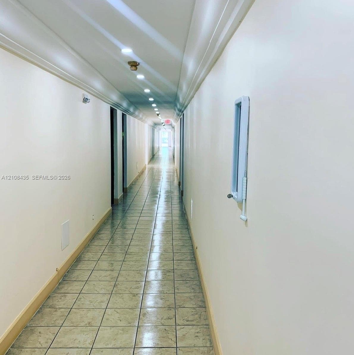 Hallway featuring neutral wall finishes, tile flooring, and recessed ceiling lighting