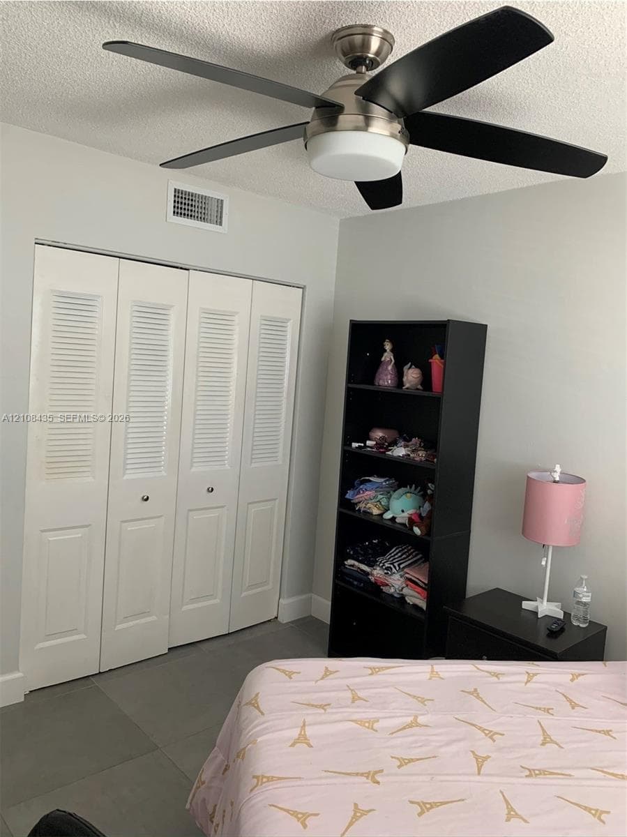 Brushed nickel ceiling fan with matte black blades and integrated light fixture, paired with four-panel louvered closet doors