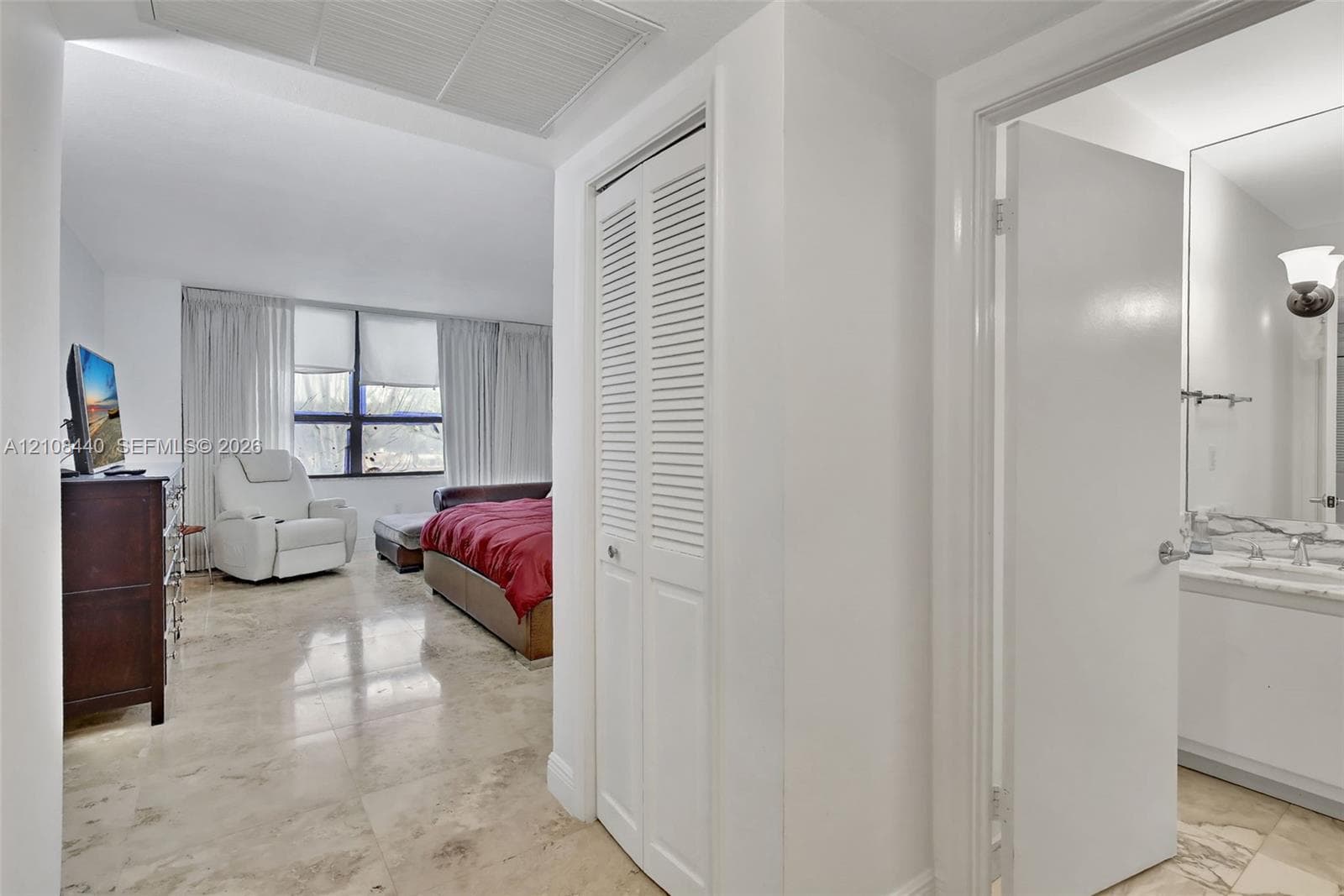 Polished stone flooring, floor-to-ceiling windows, and white bifold closet doors