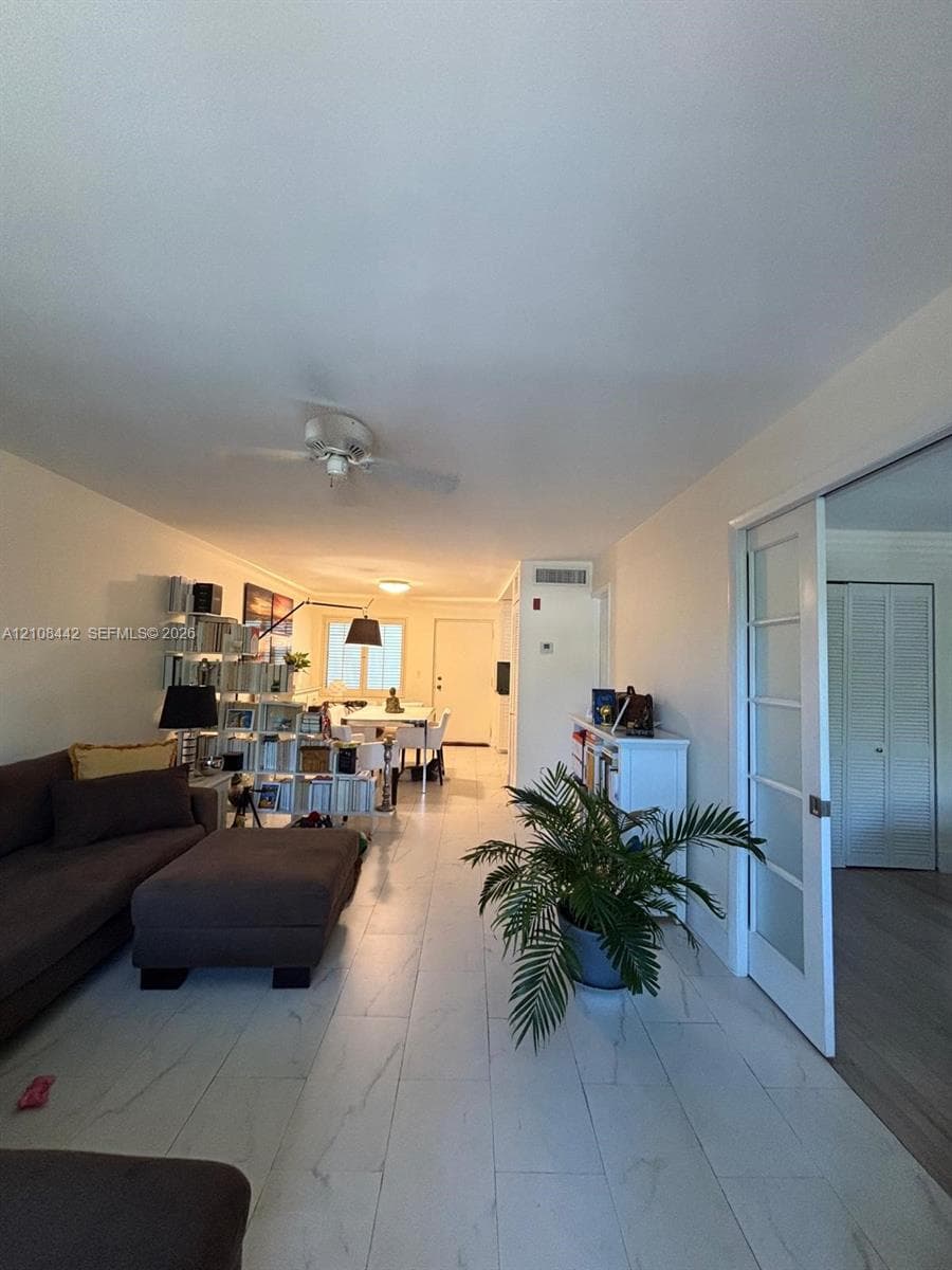 Large-format tile flooring, multi-pane glass sliding door, and ceiling fan fixture