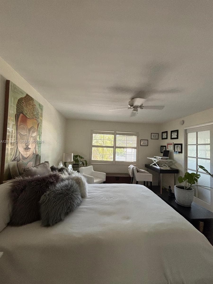 Room featuring white interior walls, plantation shutters, a ceiling fan, and multi-lite French doors