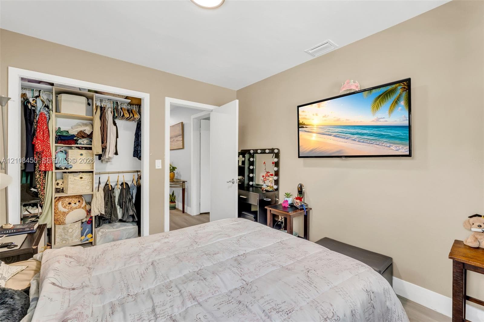 Neutral wall tones, recessed ceiling lighting, and a reach-in closet featuring built-in shelving