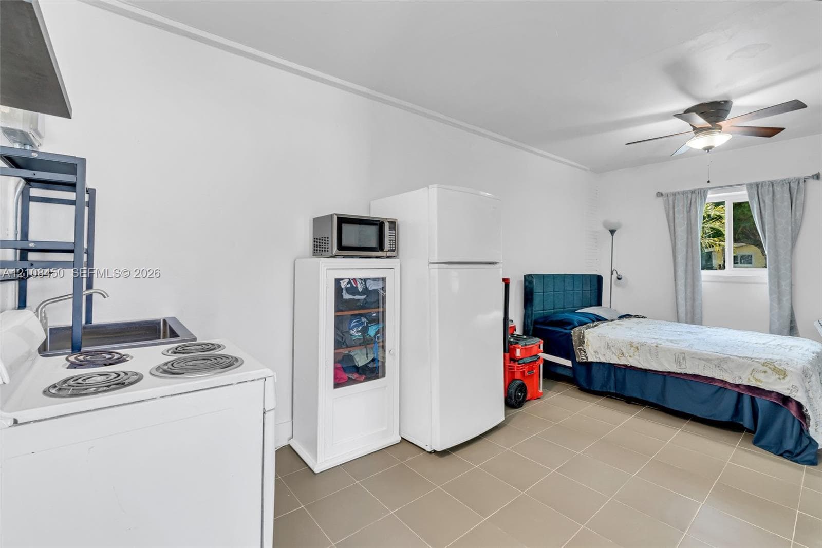 Ceramic tile flooring, electric range, stainless steel sink, and ceiling fan