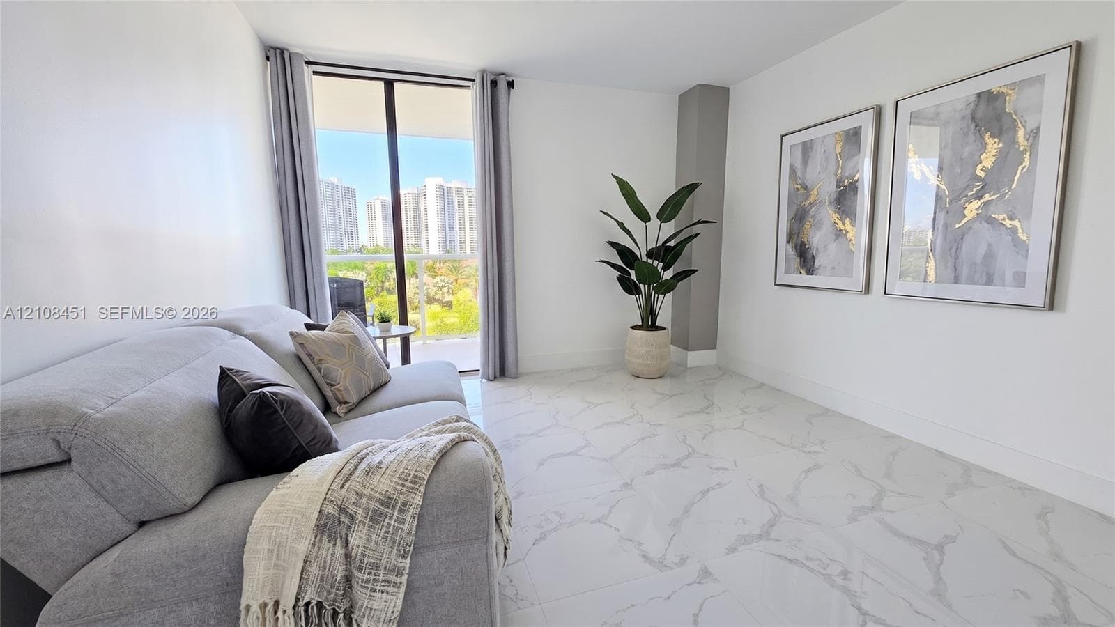 Living area featuring large-format veined tile flooring, neutral walls, and a glass sliding door providing access to a balcony with metal railing