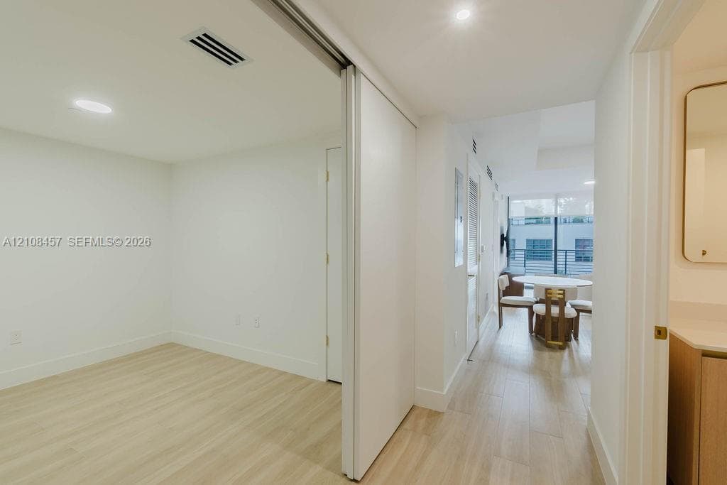 Interior space featuring wood-finish flooring, recessed lighting, and a large sliding door with a mirror finish
