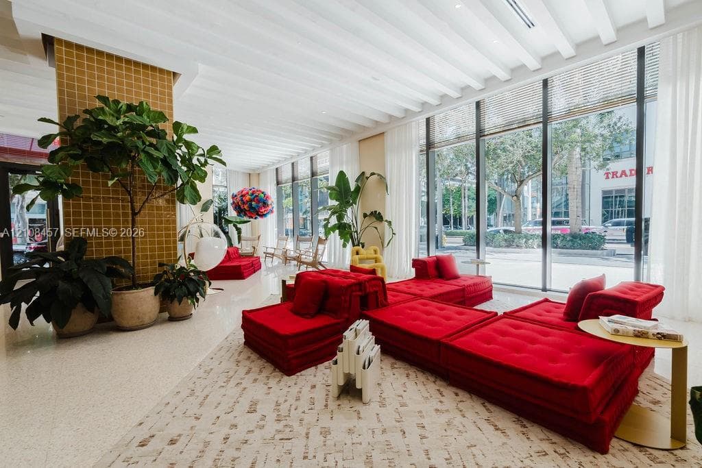 Floor-to-ceiling glass windows, ribbed ceiling detailing, tile-accented structural column, and polished stone flooring