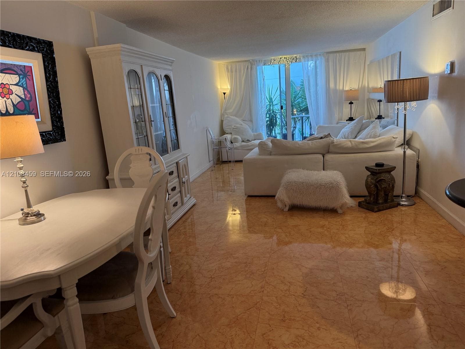 Polished stone flooring, sliding glass door with exterior balcony access, and recessed ceiling lighting