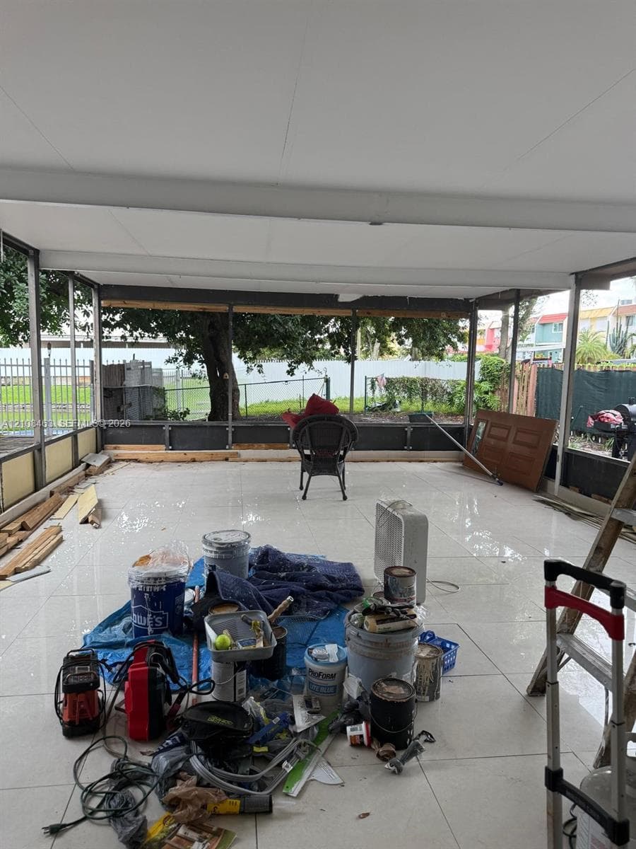 Screened-in patio featuring polished tile flooring, a solid ceiling, and metal framing