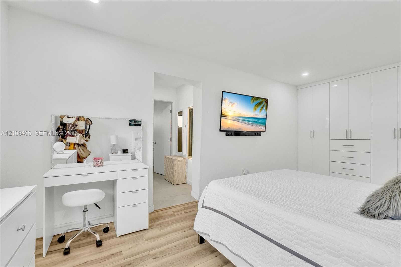 Interior space featuring wood-finish flooring, recessed lighting, and expansive floor-to-ceiling built-in cabinetry with integrated drawers