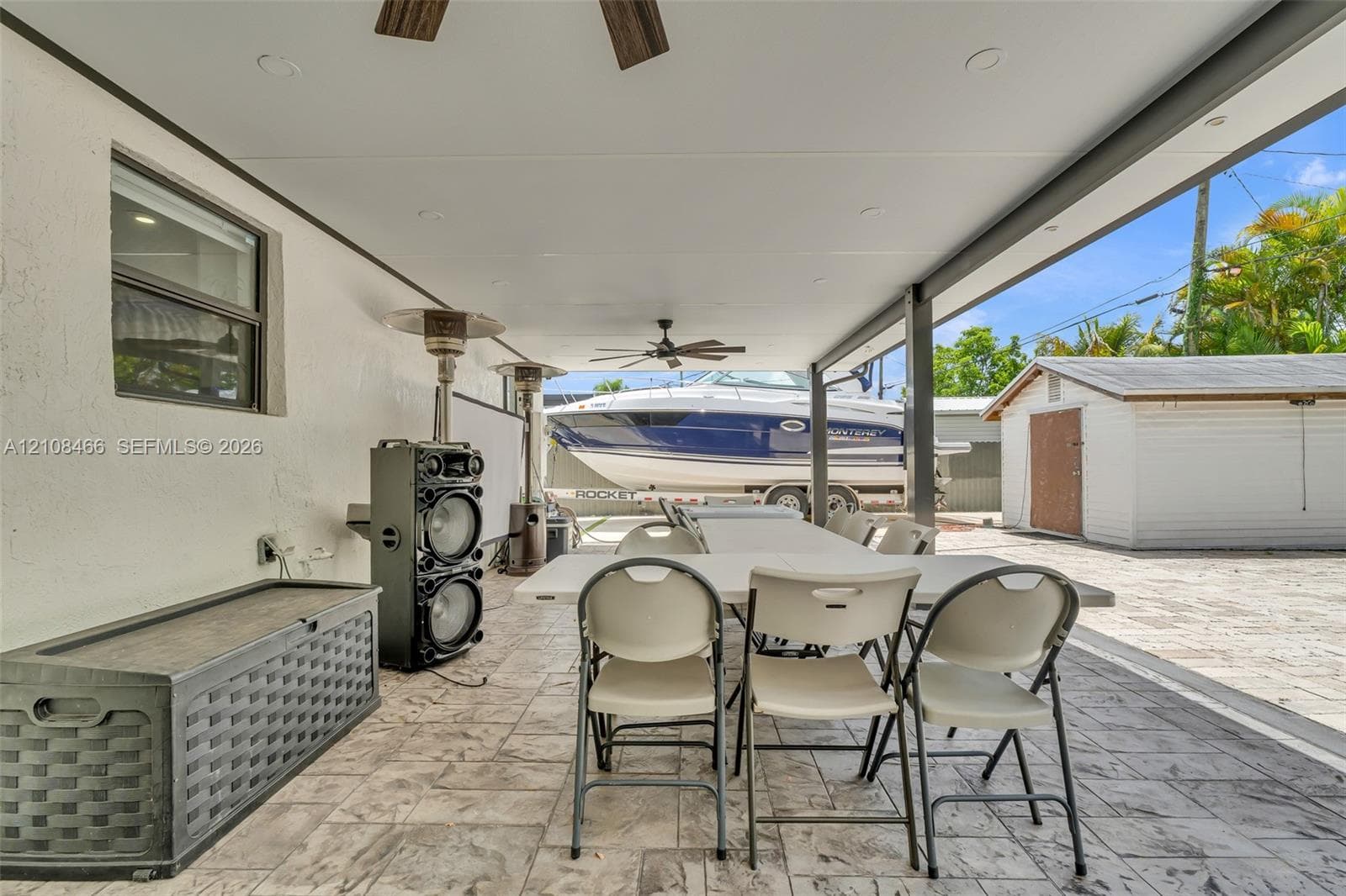 Covered patio featuring stamped concrete flooring, a ceiling fan, and recessed lighting, with an exterior storage structure