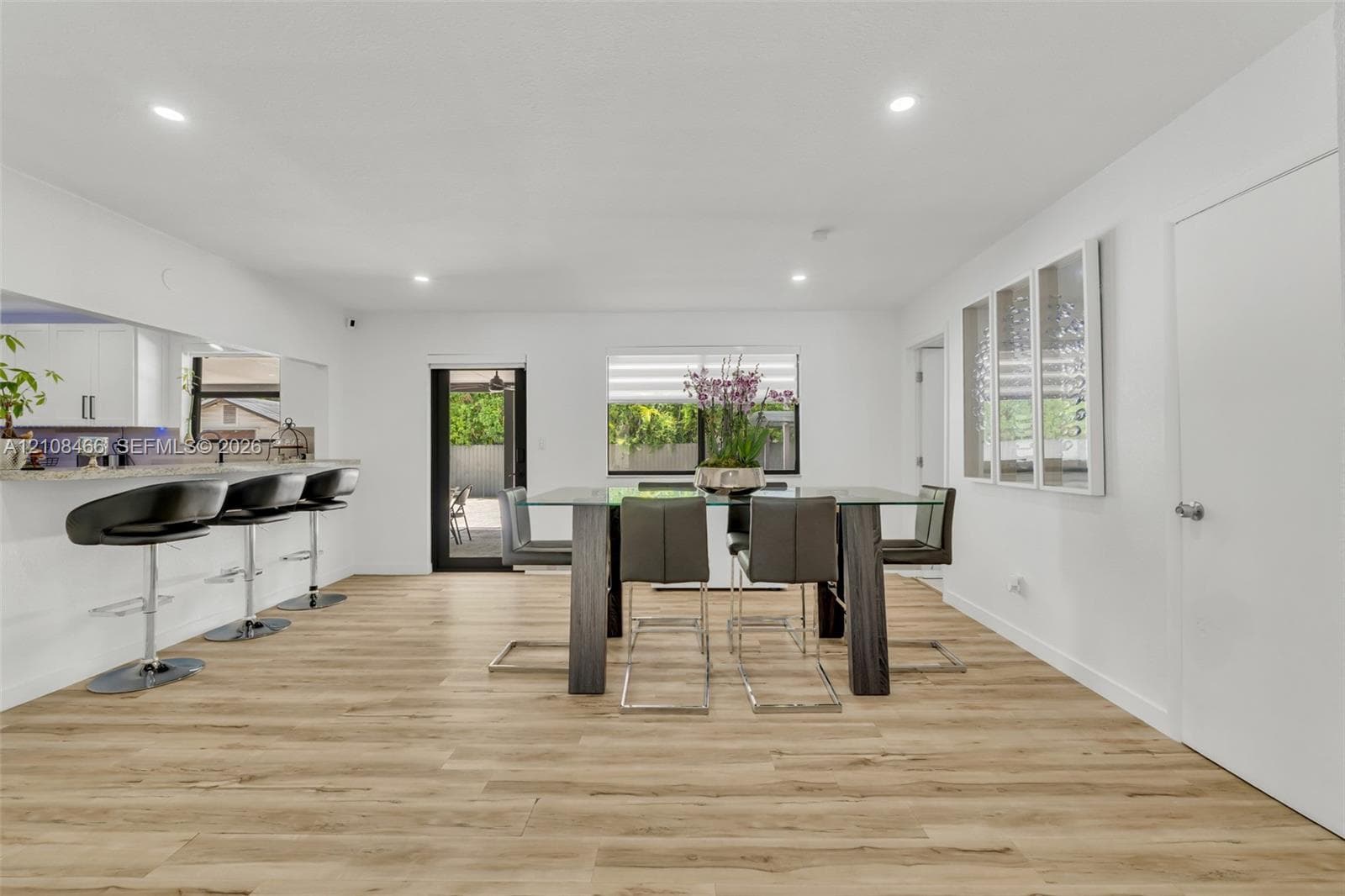 Open floor plan featuring wood-finish flooring, recessed lighting, and a kitchen breakfast bar with stone-surfaced countertop