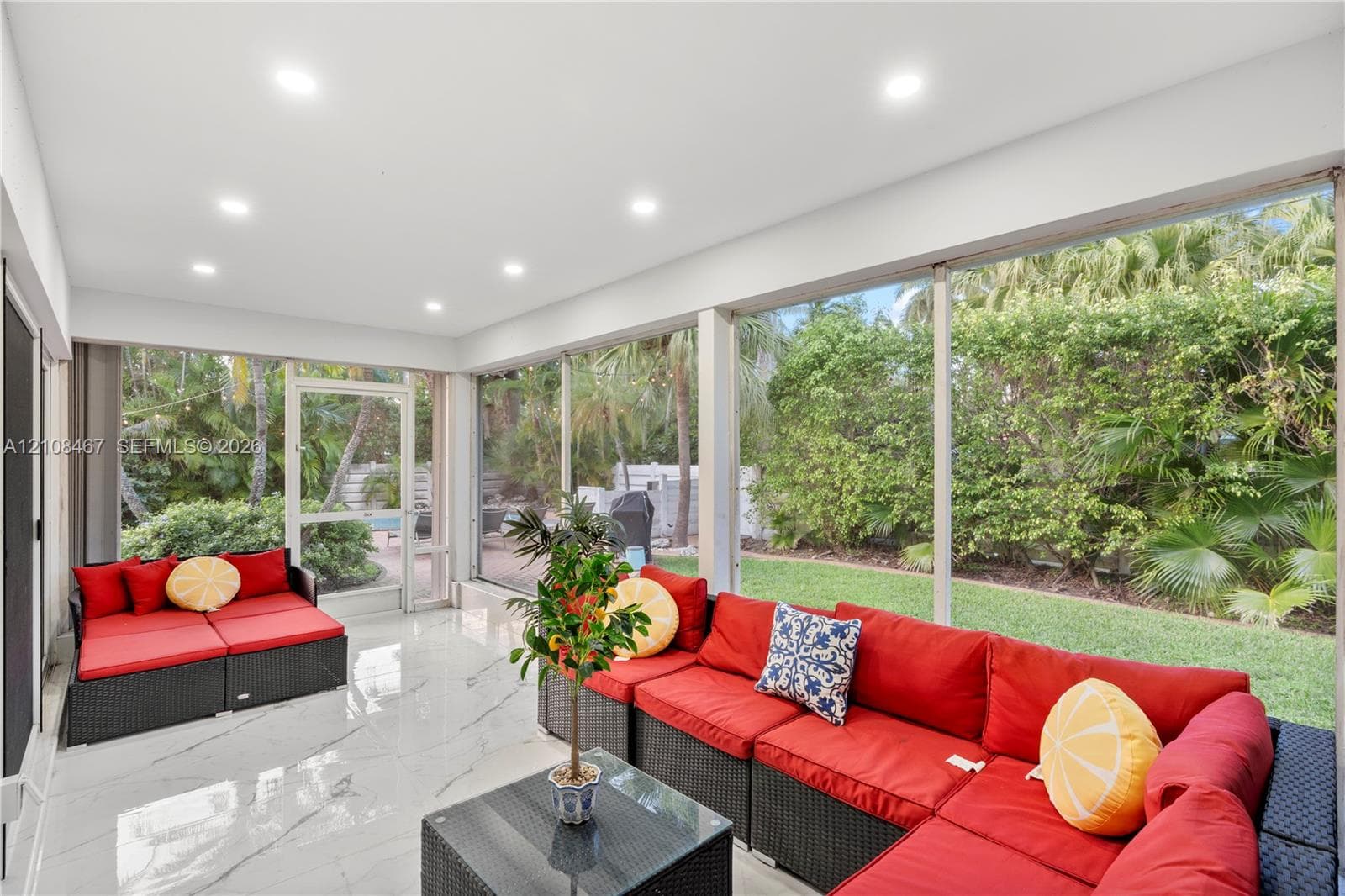 Enclosed lanai featuring large-format stone-finish tile flooring, recessed ceiling lighting, and floor-to-ceiling screen paneling