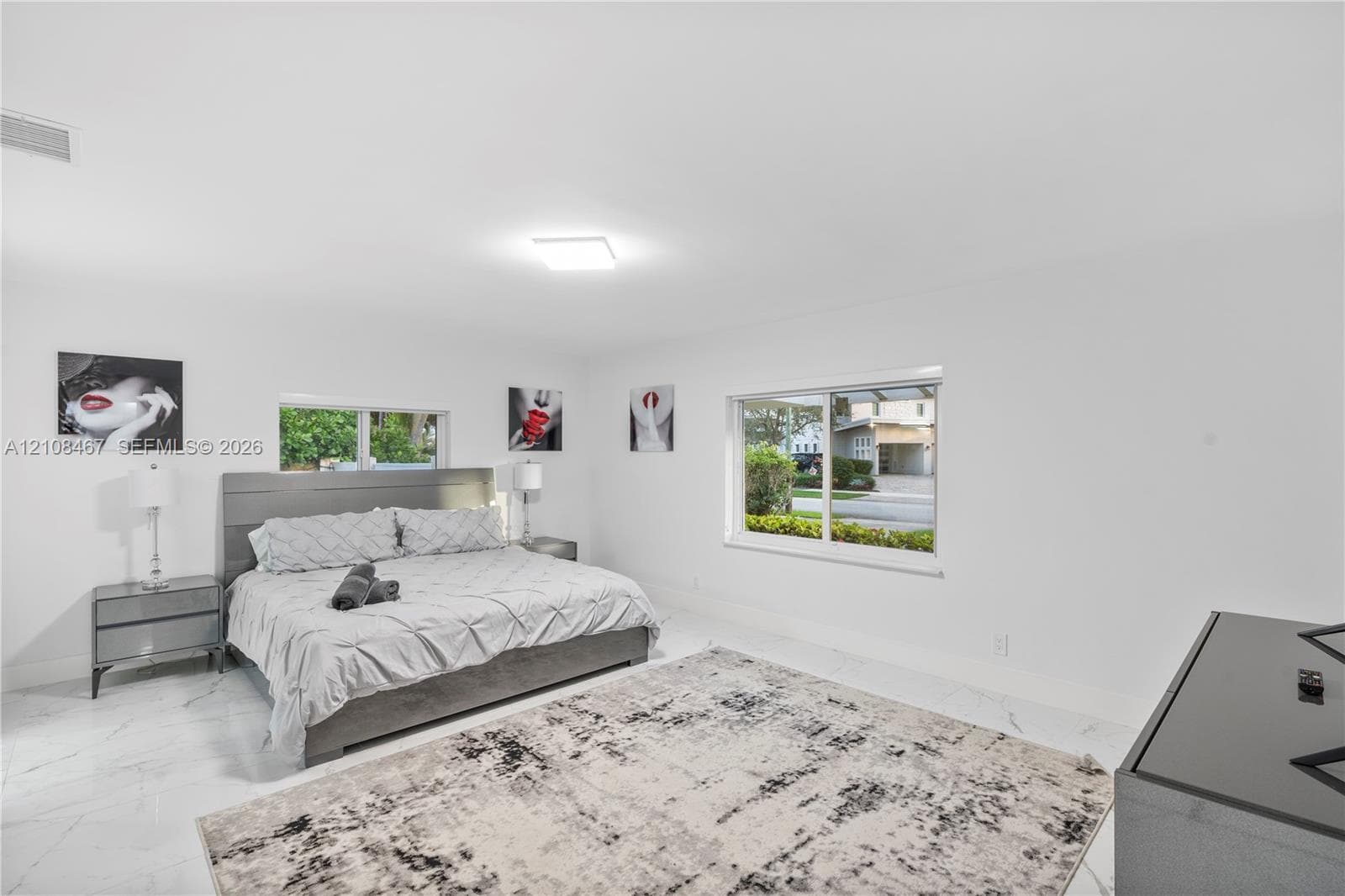 Expansive room featuring large-format white tile flooring, neutral walls, and dual sliding windows