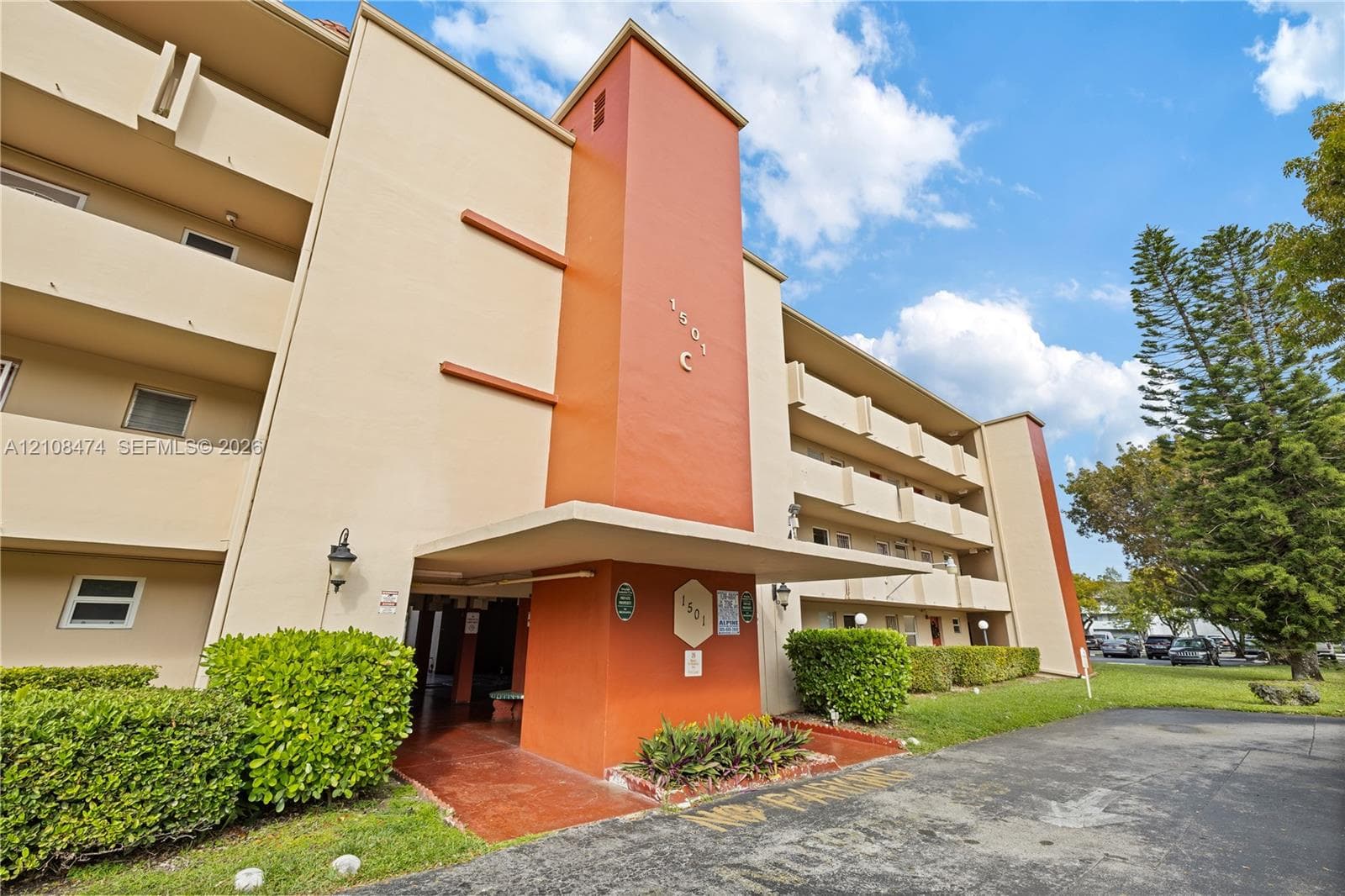 Multi-story exterior featuring a concrete facade, covered entryway, tiered balcony levels, and integrated wall-mounted lighting