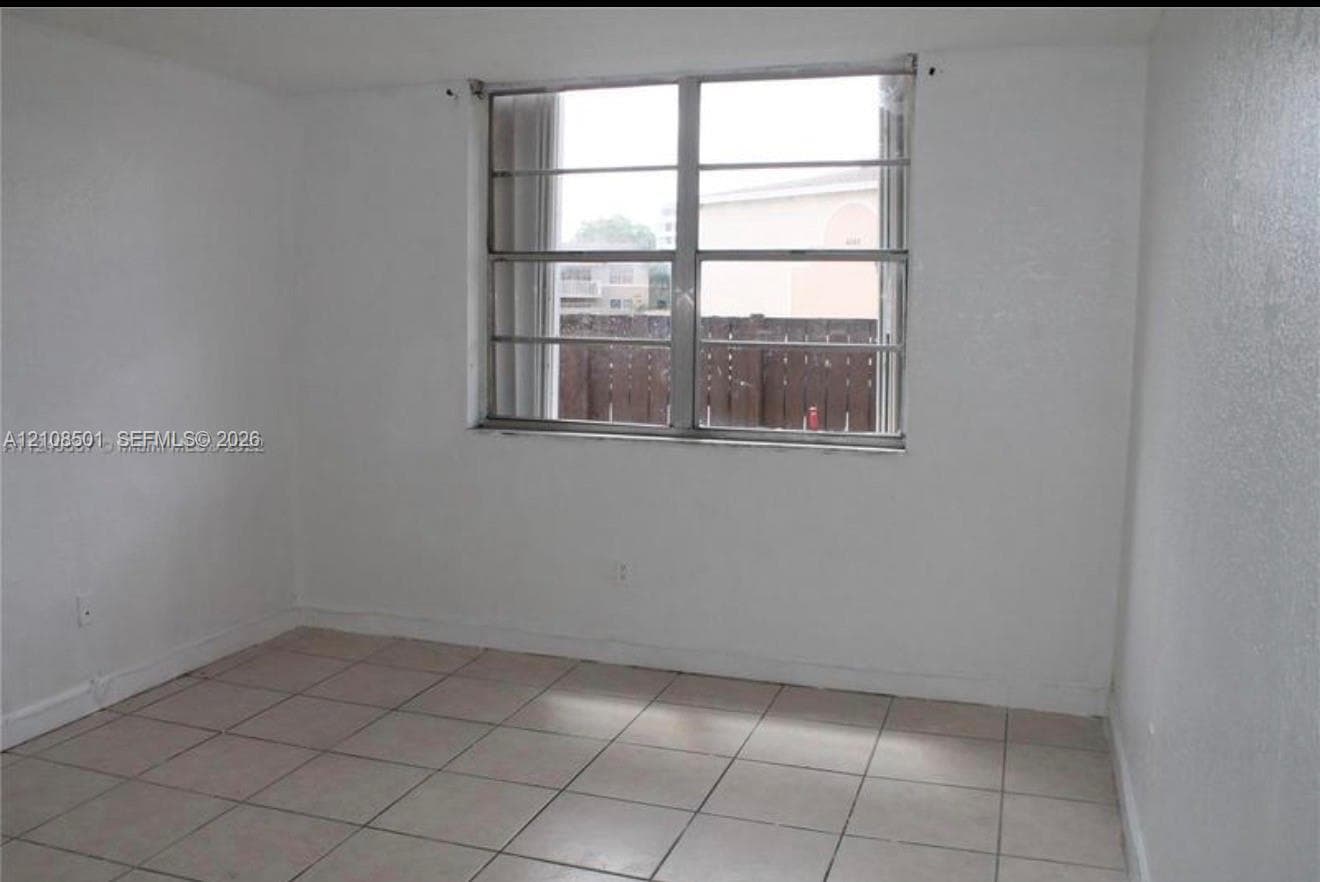 Interior space featuring neutral wall finishes, tile flooring, and a large horizontal sliding window with metal framing