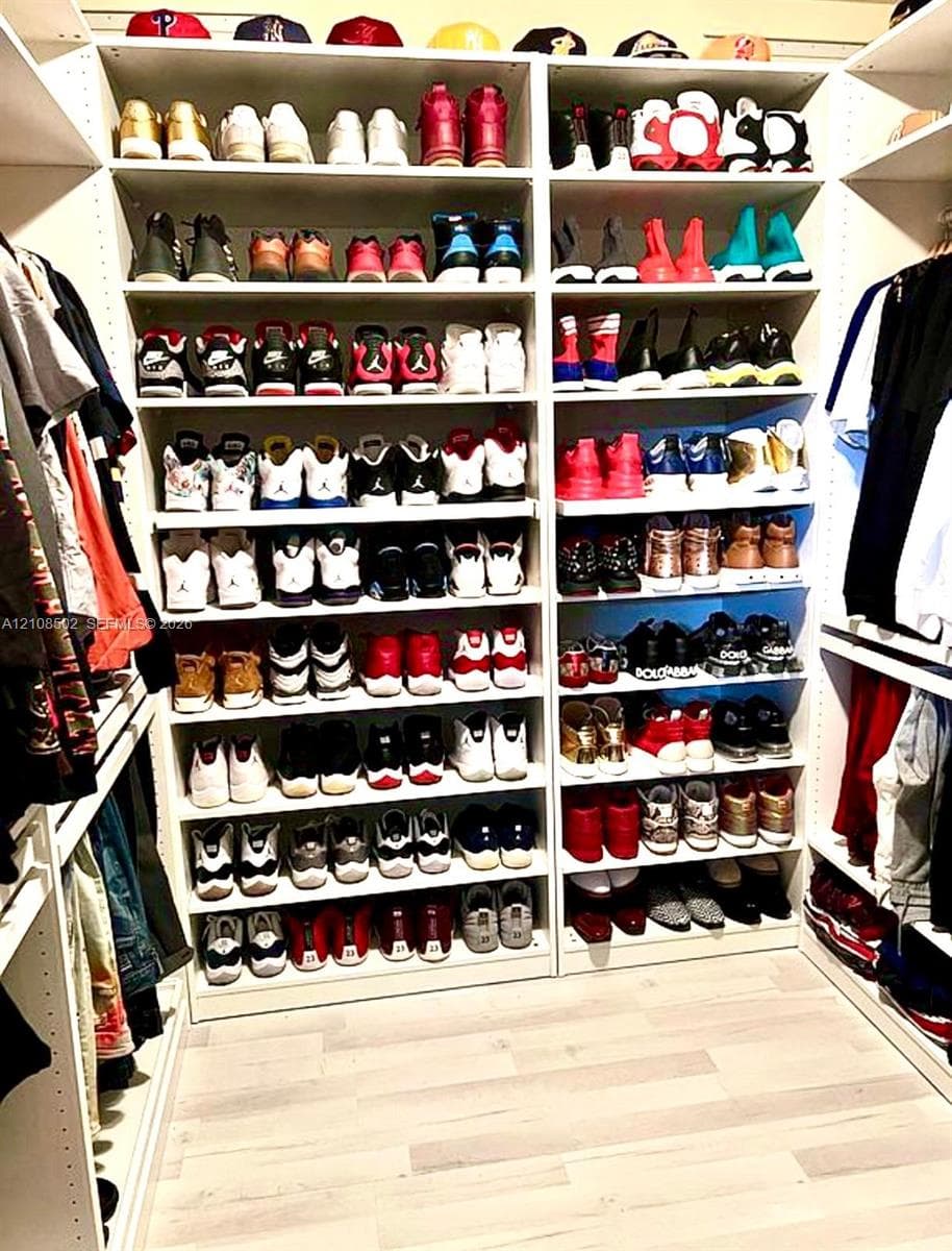 Custom floor-to-ceiling shelving system with adjustable tiers and light-toned wood-finish flooring