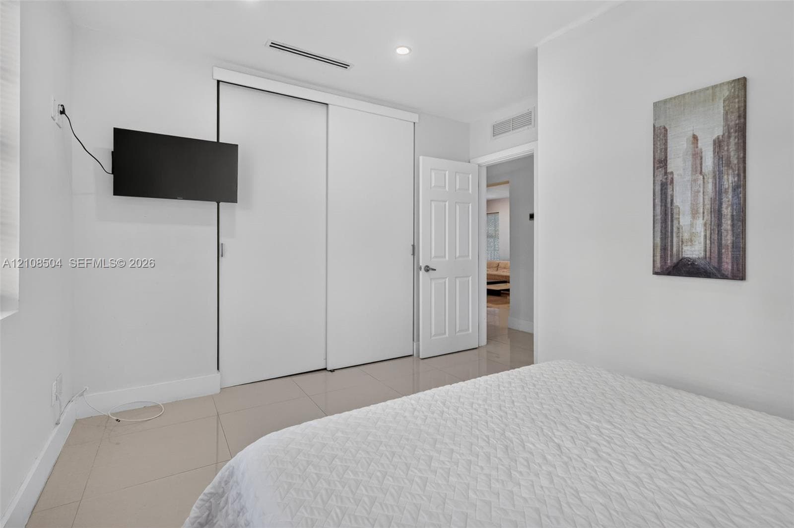 Neutral-toned ceramic tile flooring, sliding-door closet, recessed lighting, and six-panel interior door