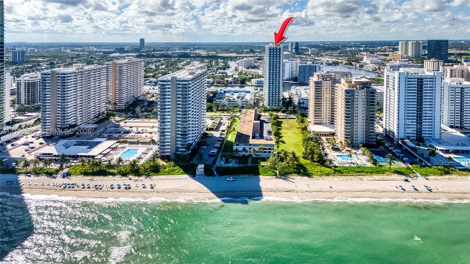 Aerial perspective of a high-rise residential structure situated along a coastal waterfront