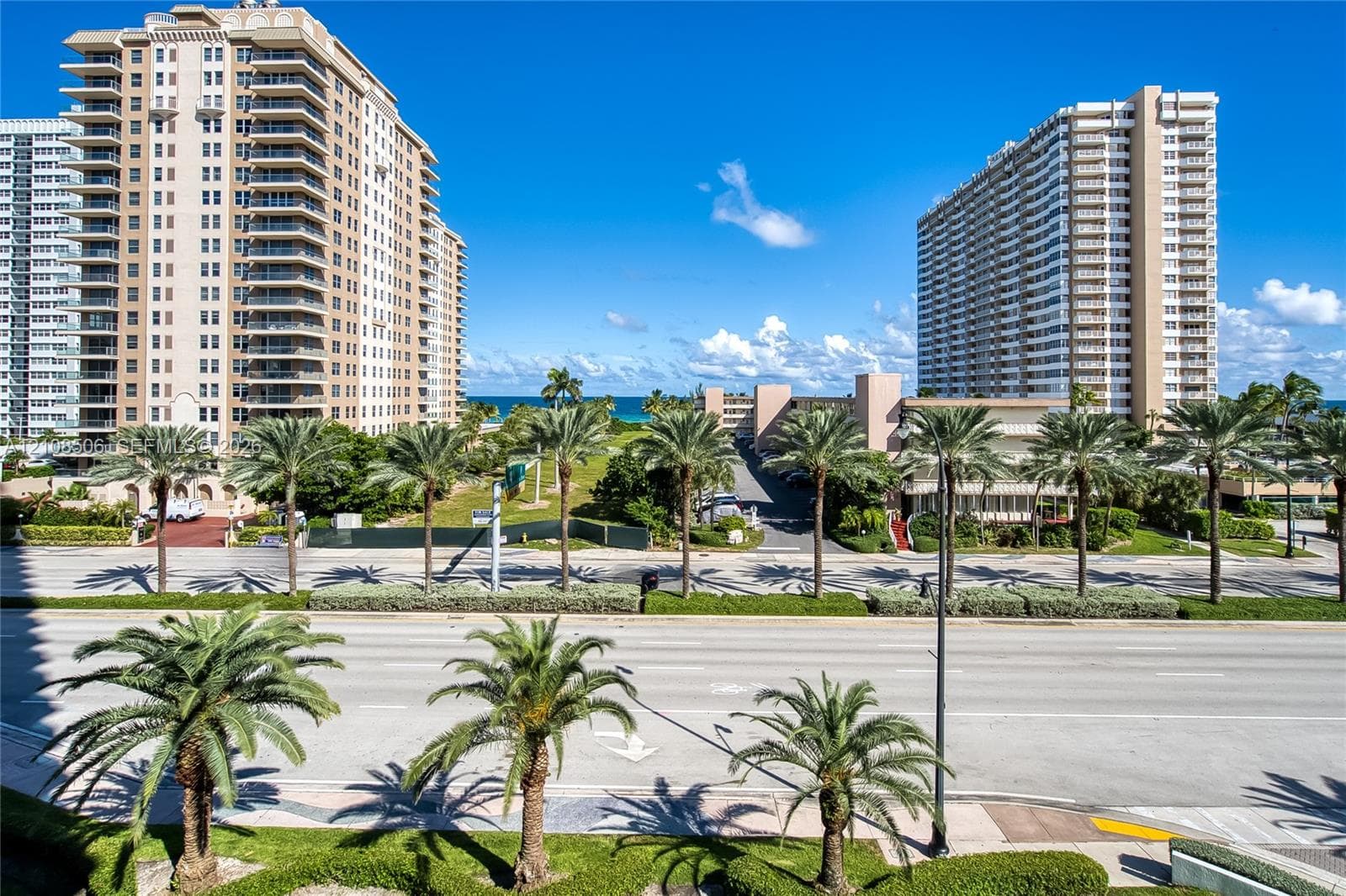 High-rise building exteriors featuring balconies and coastal landscaping with mature palm trees