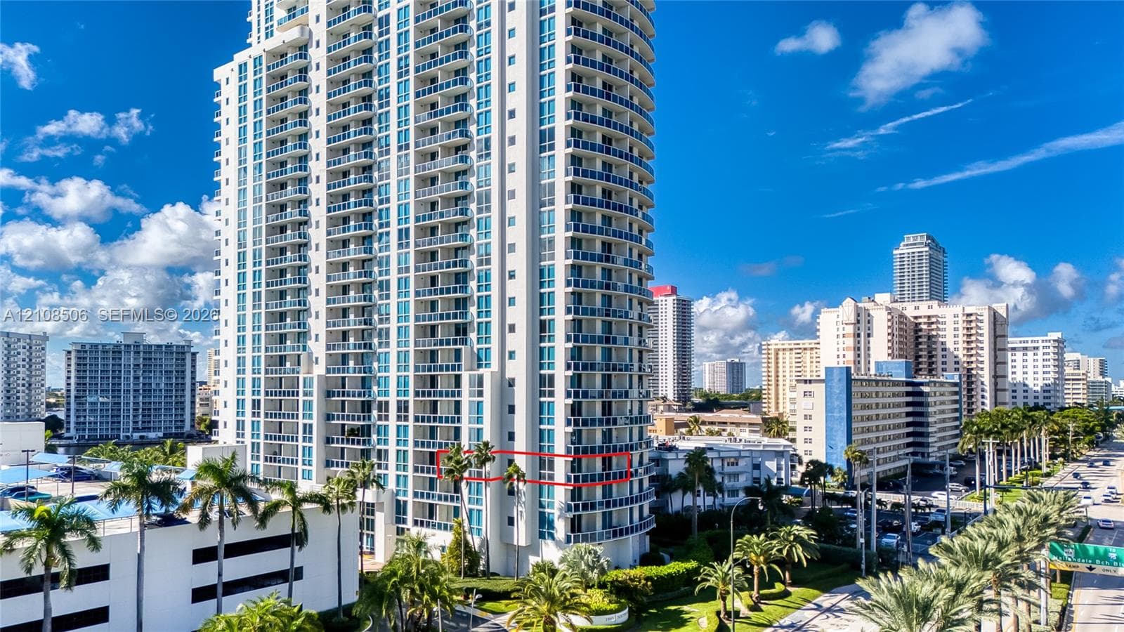 High-rise residential tower featuring a glass facade, private balconies, and concrete construction
