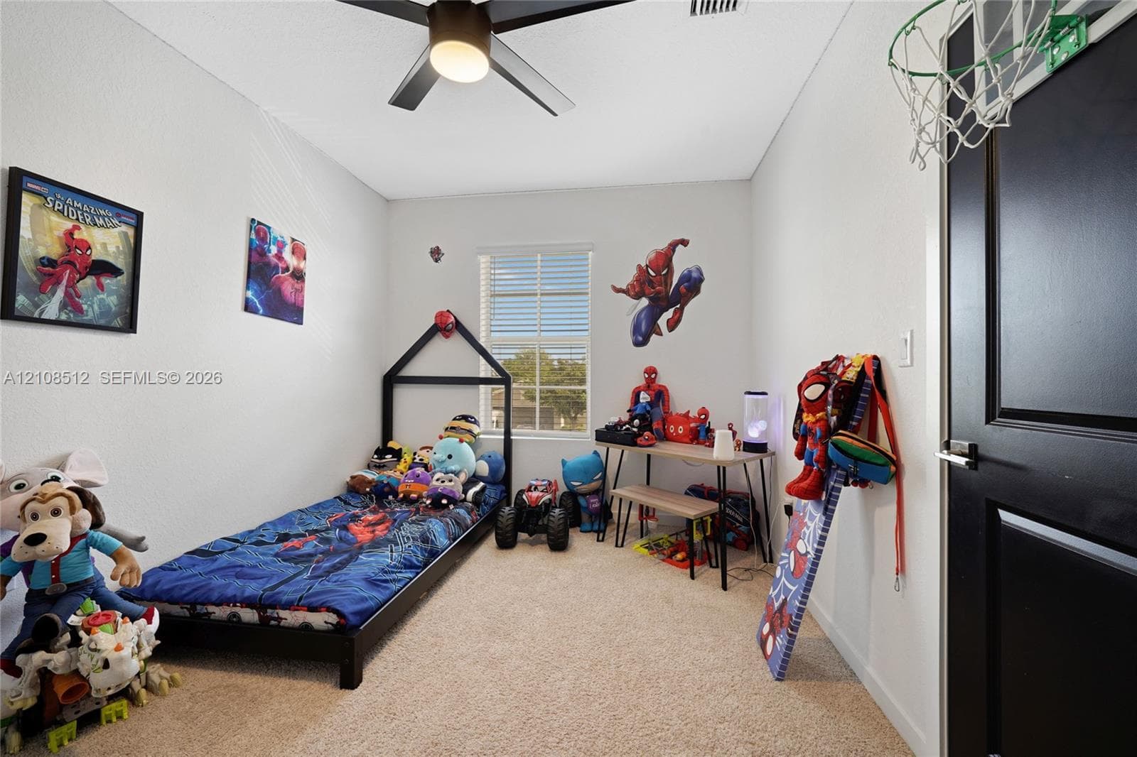 Neutral wall finish, carpeted flooring, window with blinds, ceiling fan with integrated light fixture, and door with contrasting trim