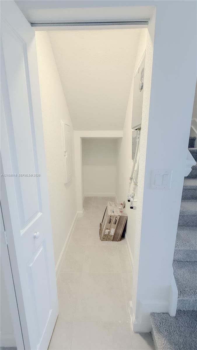 Walk-in storage space with tile flooring, neutral walls, and a recessed ceiling design