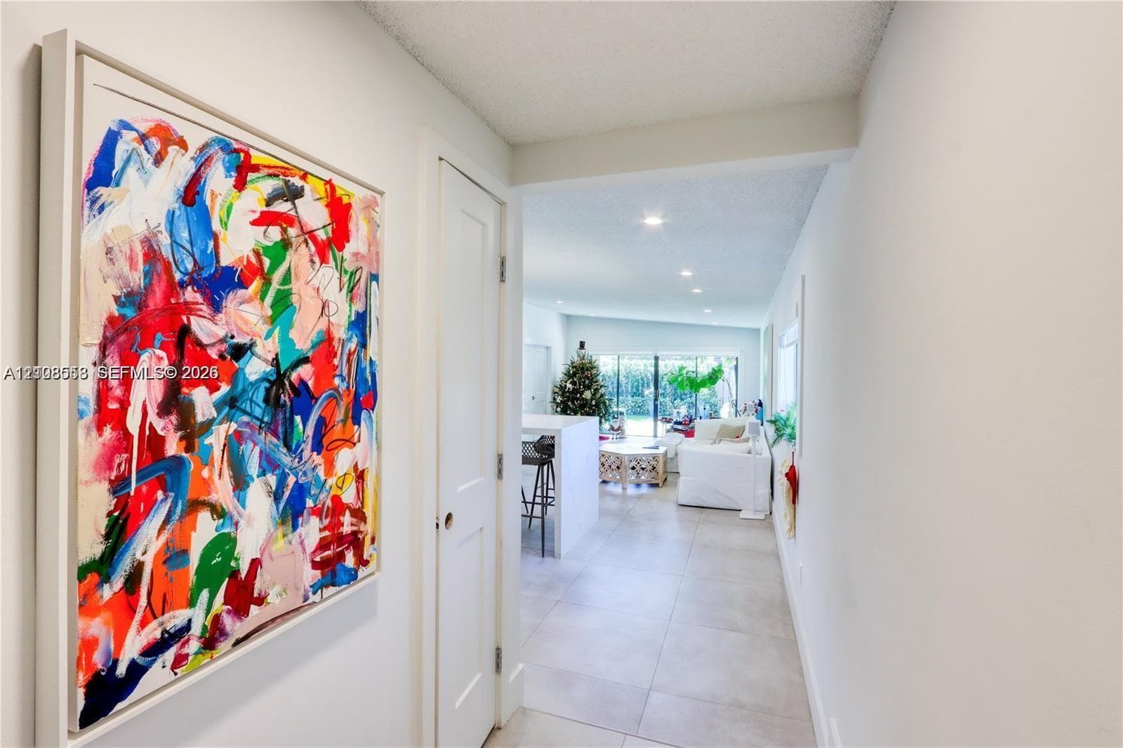 Neutral wall palette with large-format tile flooring, recessed ceiling lighting, and solid-core interior doors