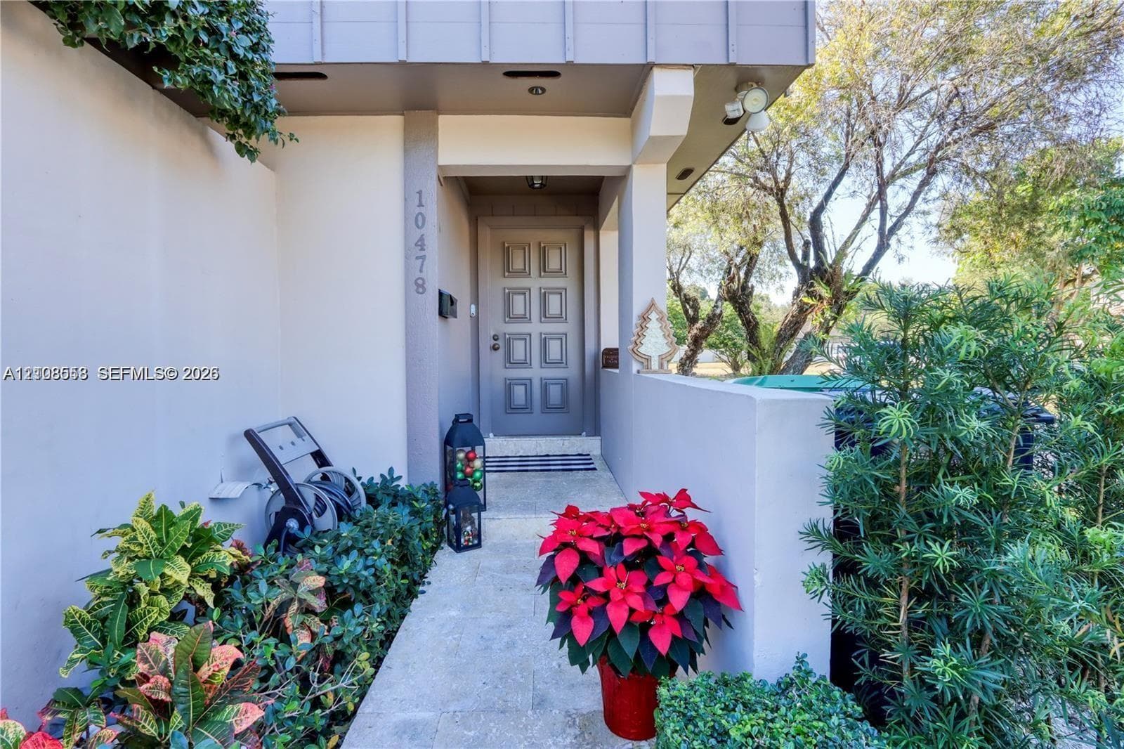 Covered entryway featuring an eight-panel entry door, exterior masonry wall, and paved walkway