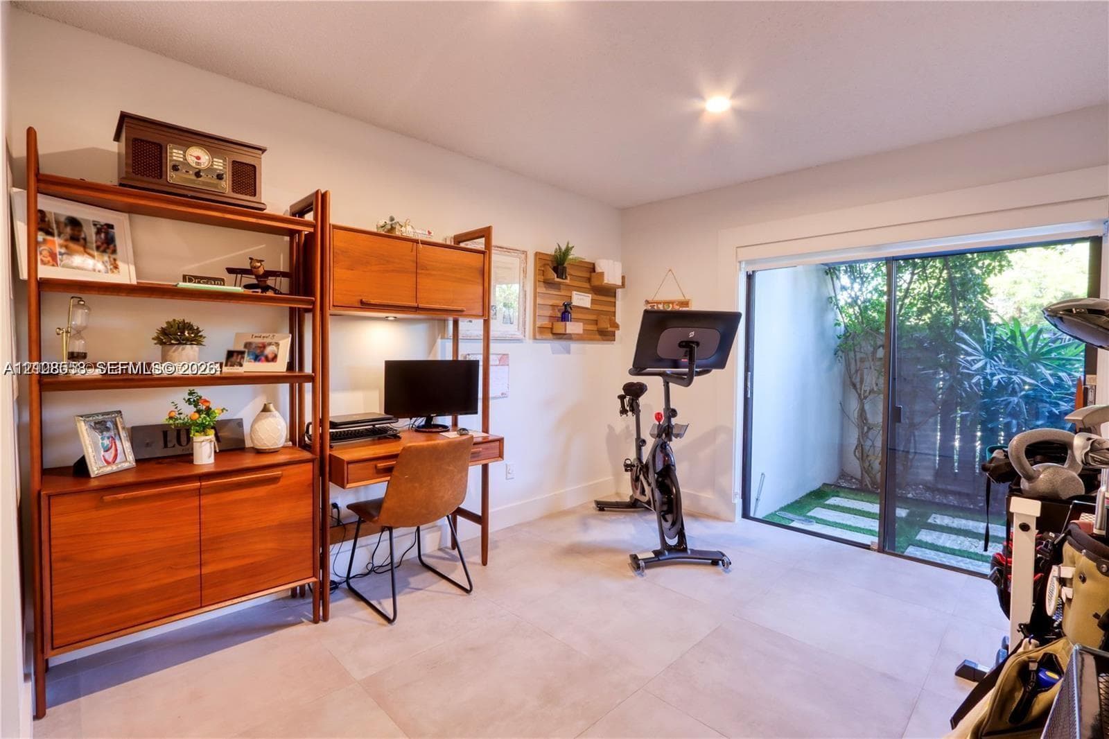 Room featuring large-format tile flooring and sliding glass doors with access to an exterior paved area
