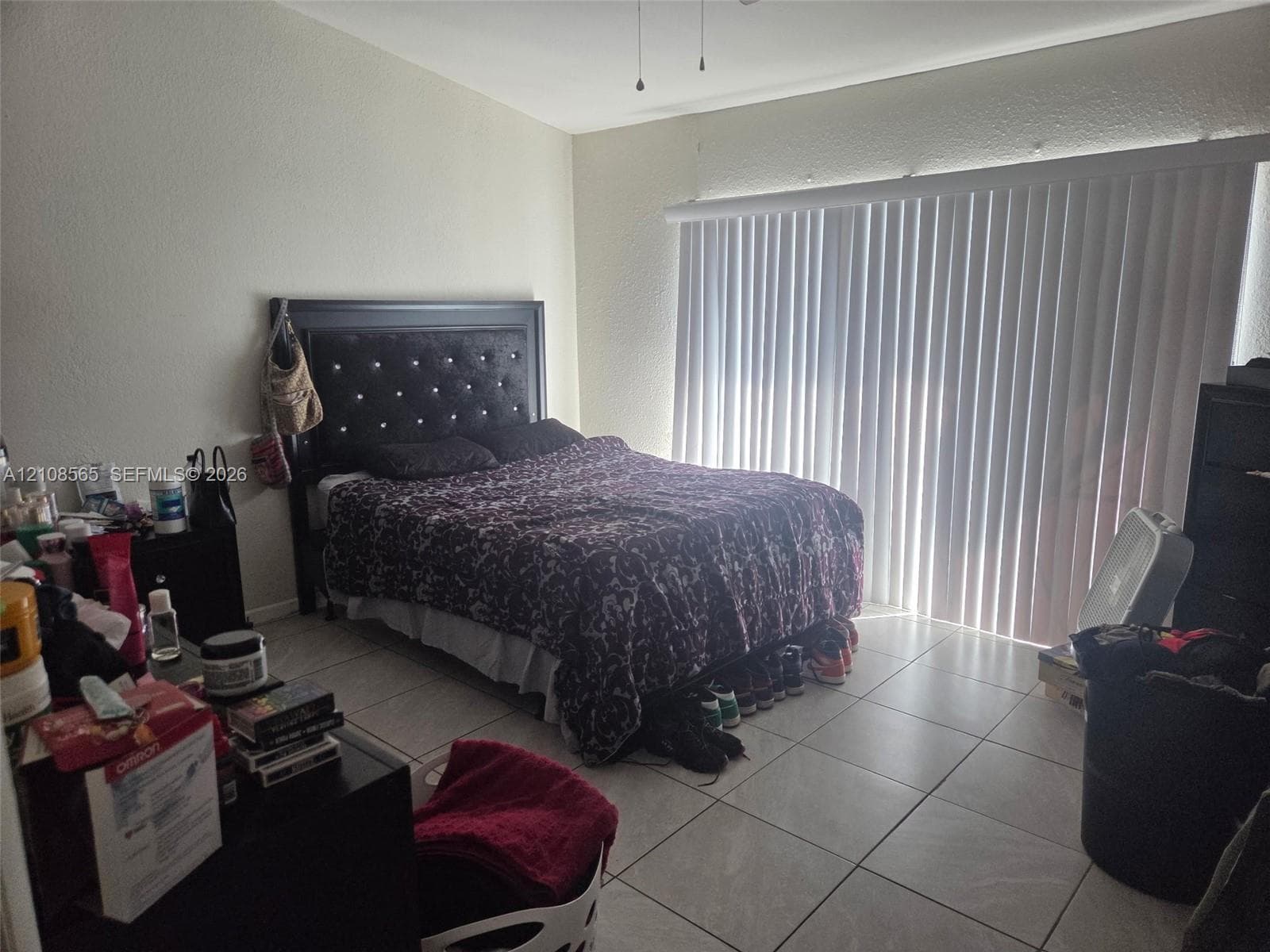 Interior room featuring large-format ceramic tile flooring and floor-to-ceiling vertical blinds