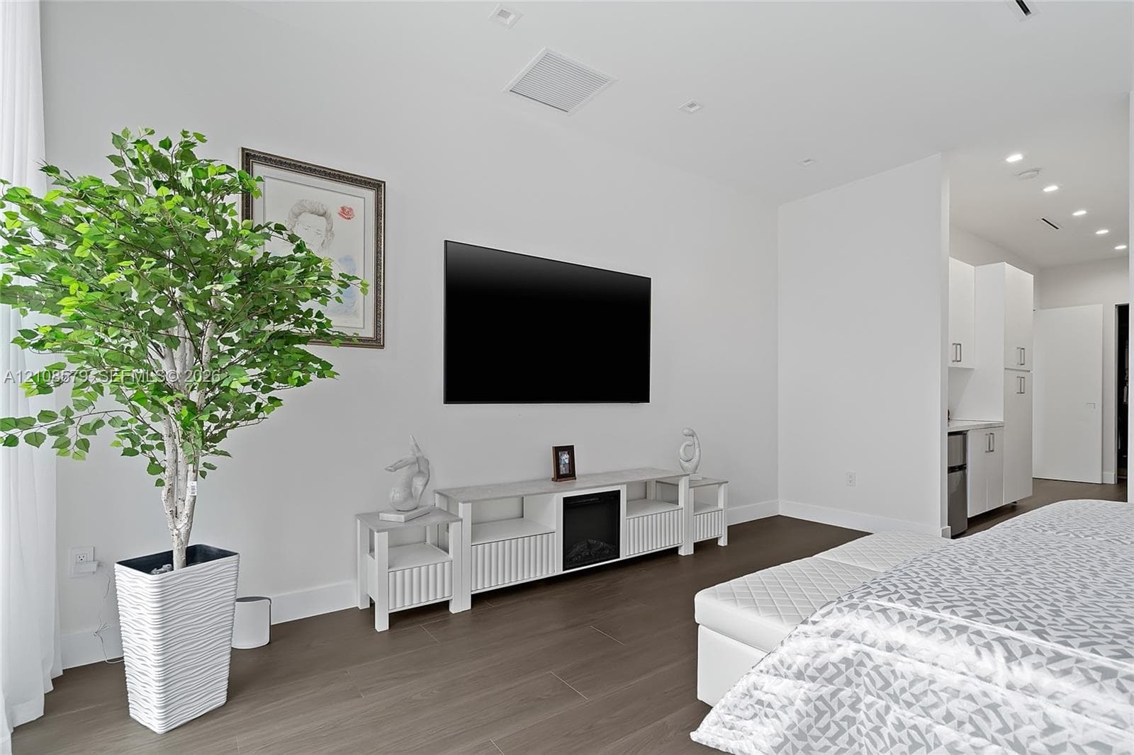 Wood-finish flooring, recessed ceiling lighting, and smooth white wall finishes