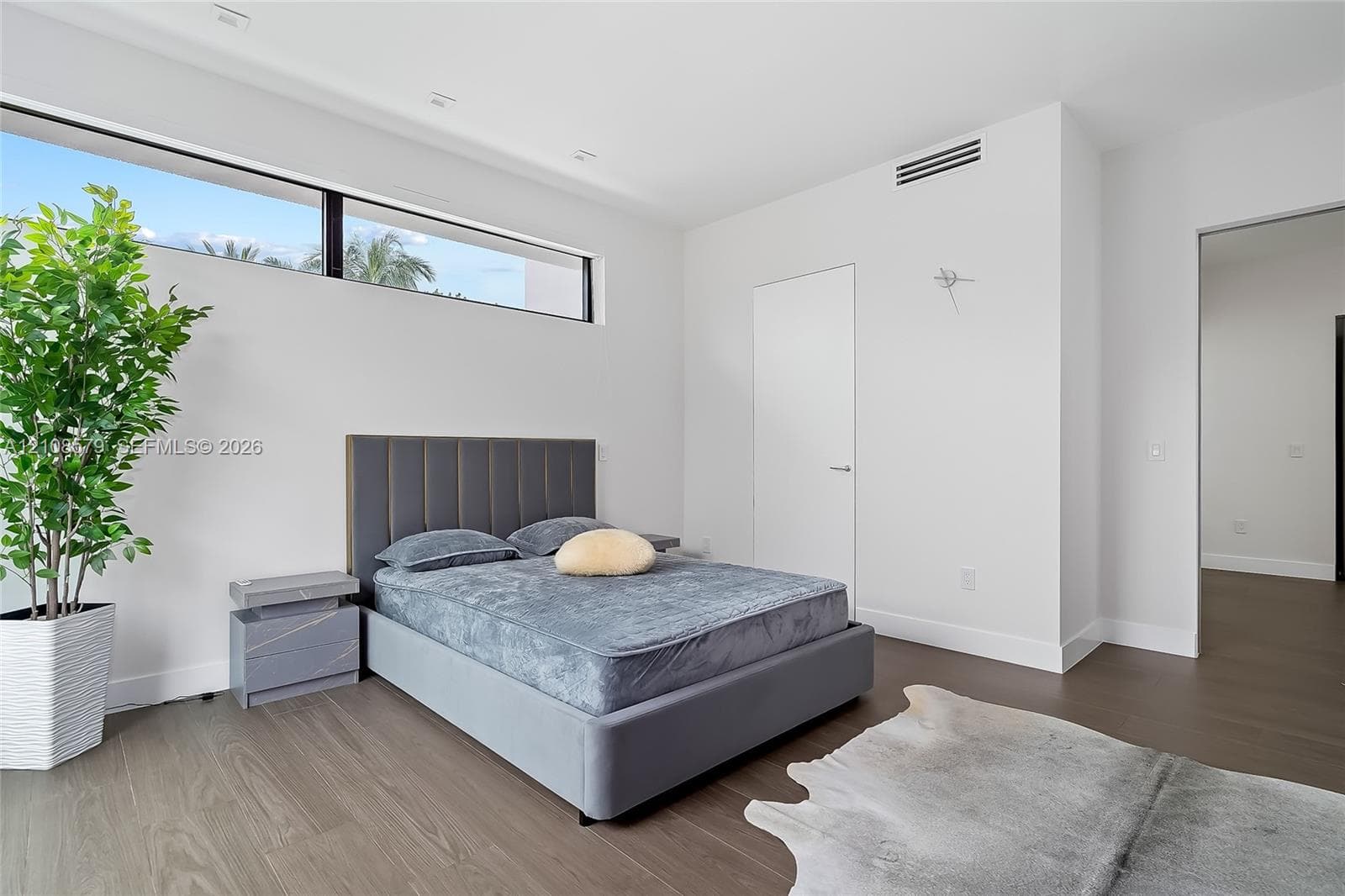 High-ceiling room featuring clerestory windows, wood-finish flooring, and recessed ceiling lighting