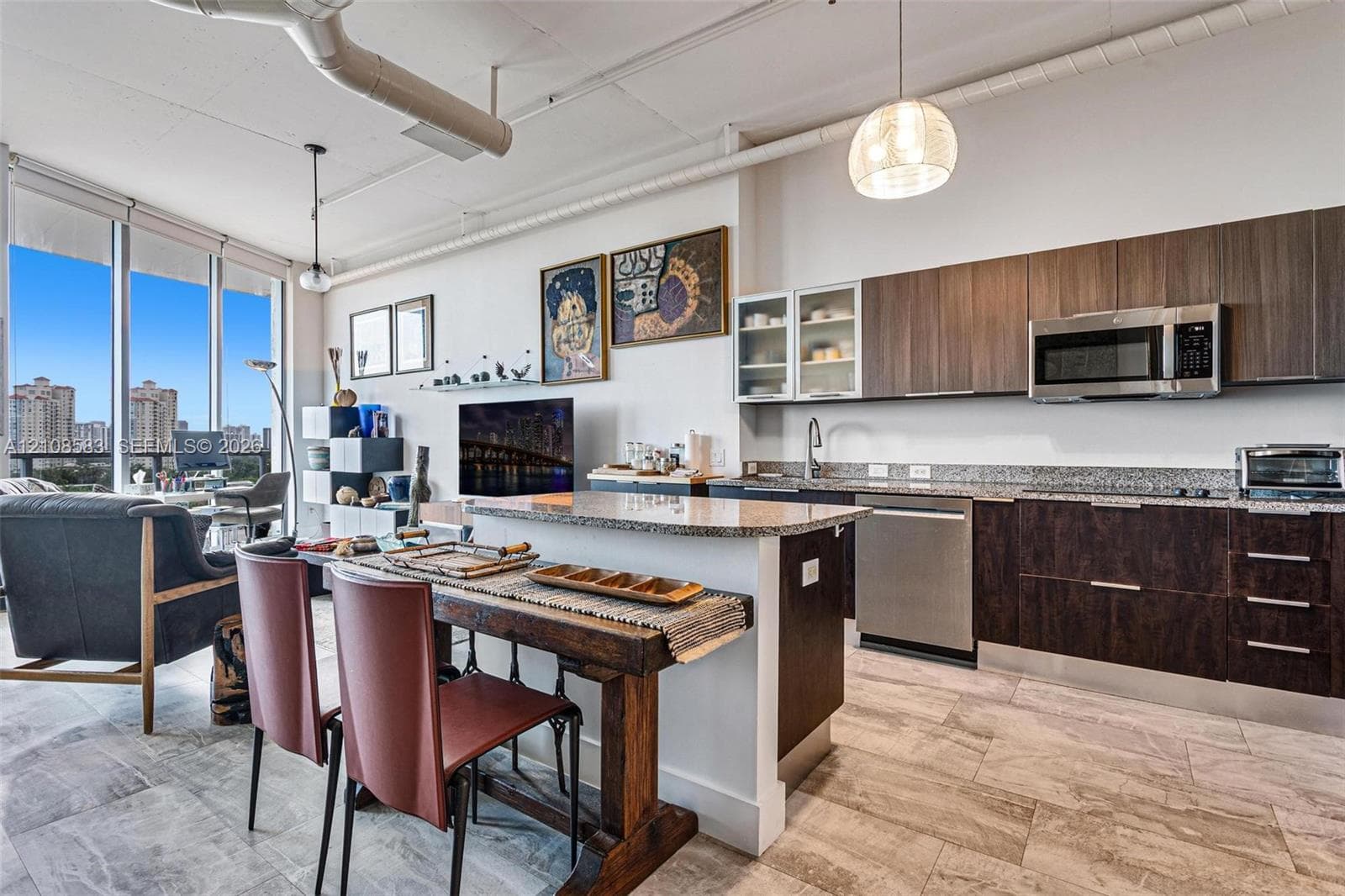 Contemporary kitchen featuring dark wood-finish cabinetry, stone countertops, stainless steel appliances, tile flooring, and floor-to-ceiling windows