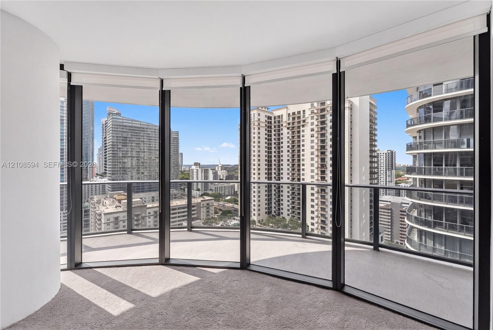 Curved balcony with glass railing, floor-to-ceiling windows, and wall-to-wall carpeting