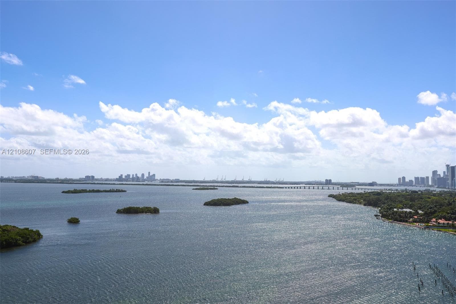 Panoramic bay waterscape featuring coastal islands, distant cityscape skyline, and bridge infrastructure