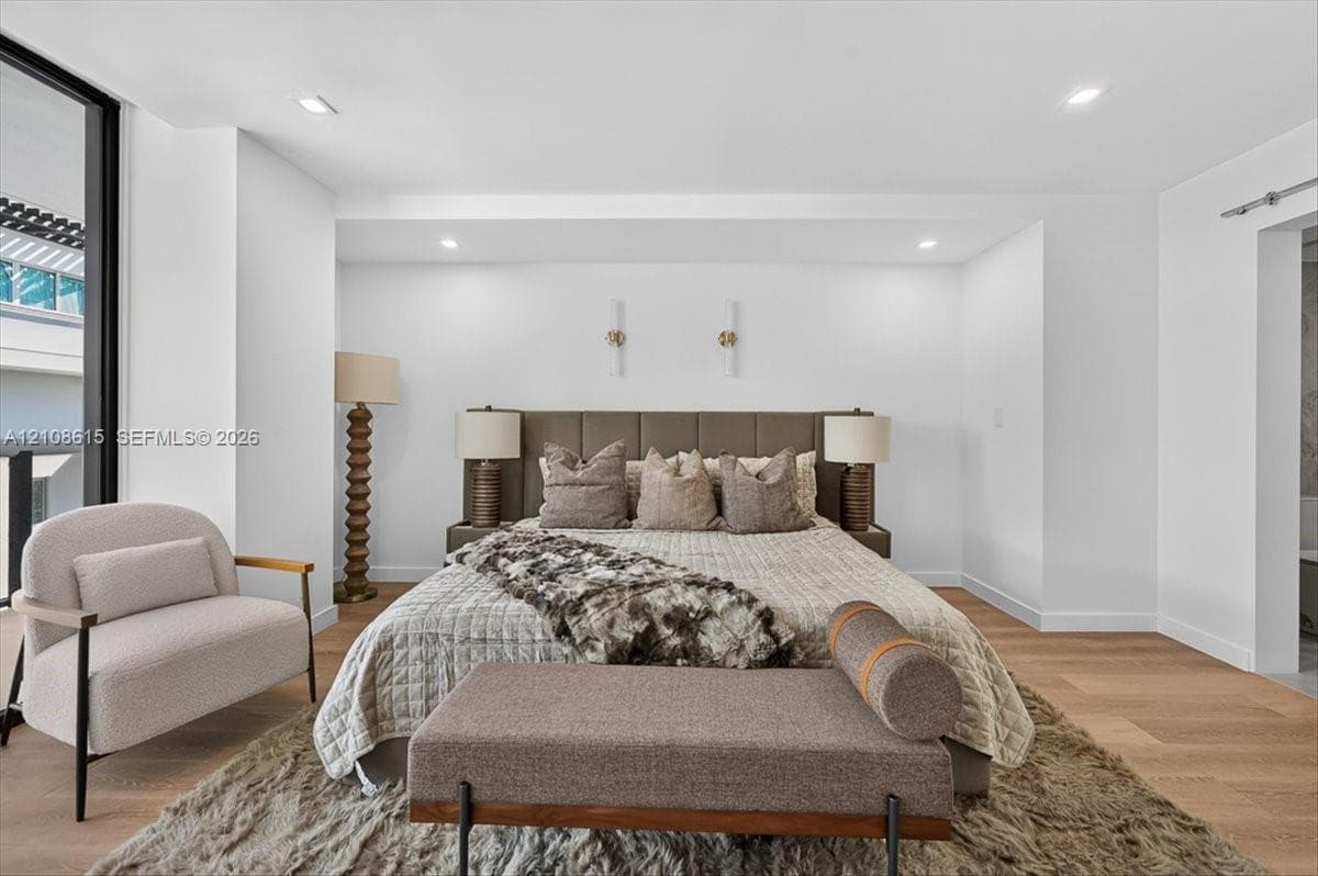 Wood-finish flooring, recessed lighting, and modern vertical wall-mounted fixtures