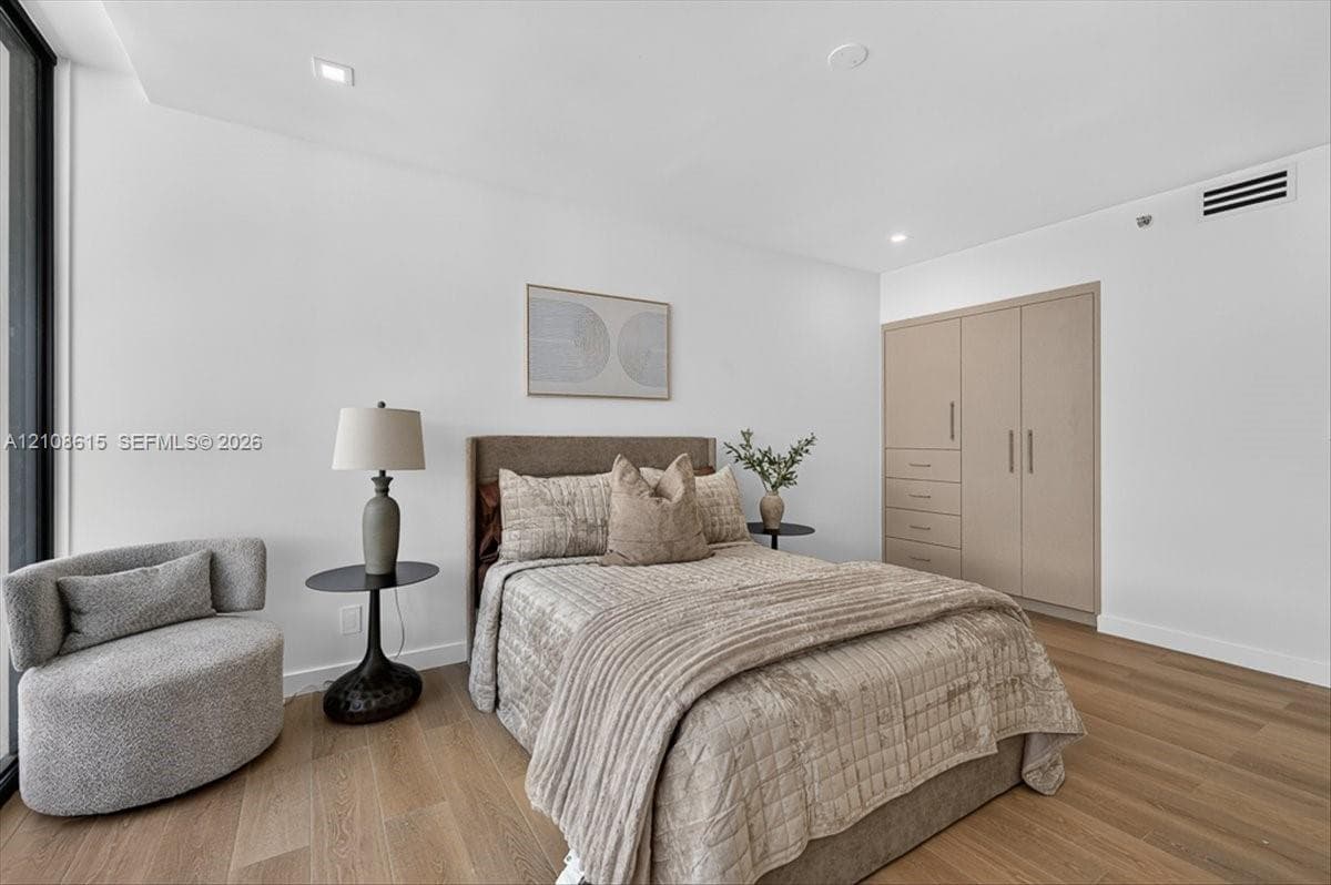Bedroom featuring wood-finish flooring, recessed lighting, and floor-to-ceiling built-in cabinetry with integrated drawer storage